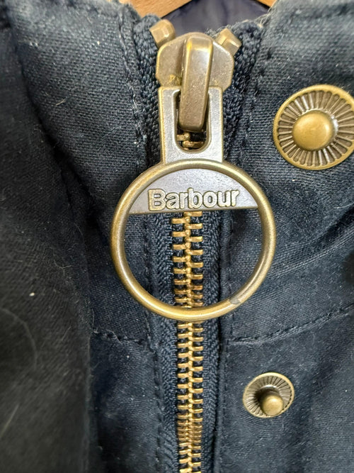 Barbour navy wax parka jacket with detachable faux fur hood and tartan lining.