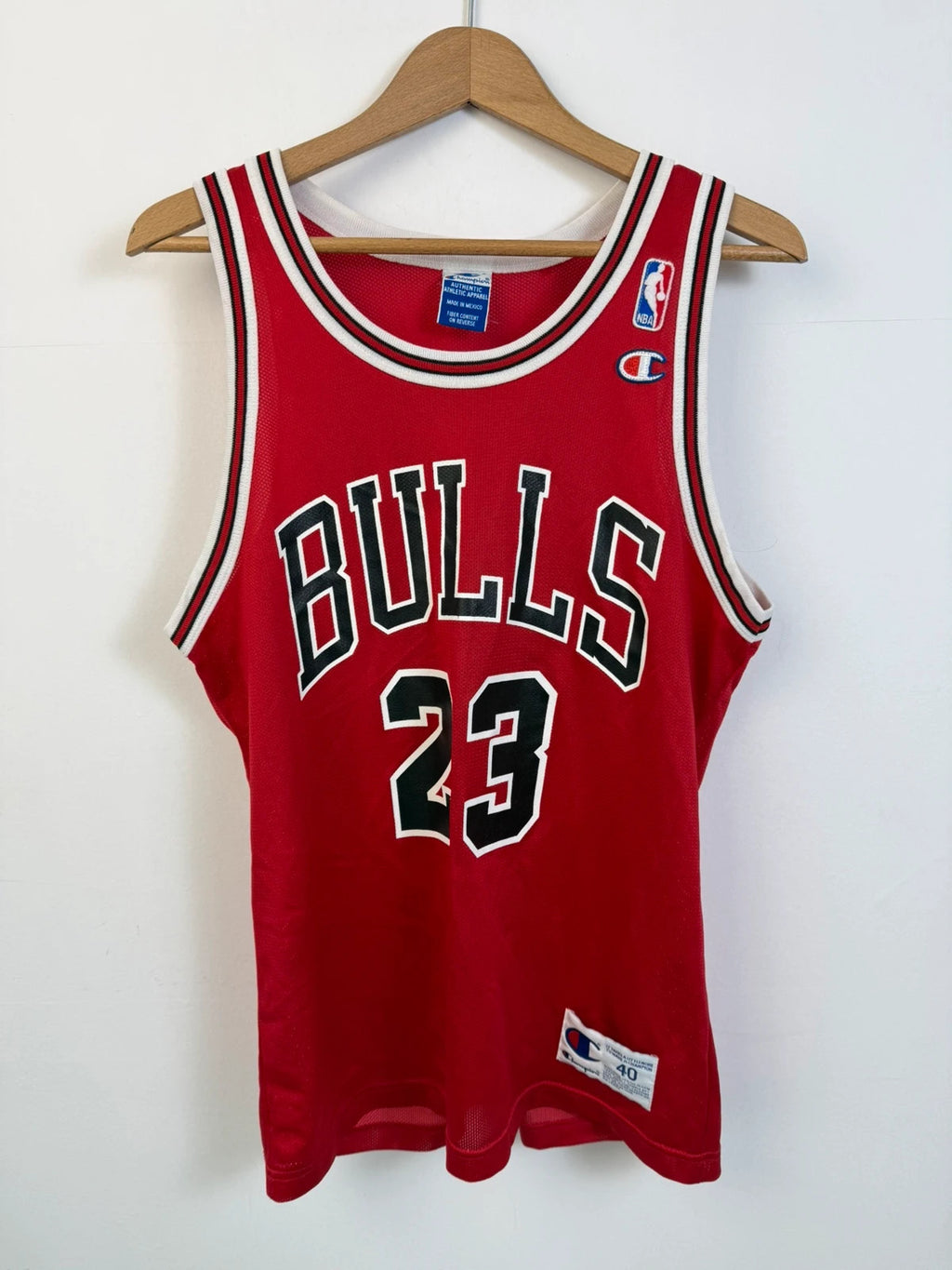 Champion red graphic tee featuring Jordan appliqué, NBA logo embroidery, and ribbed trim.