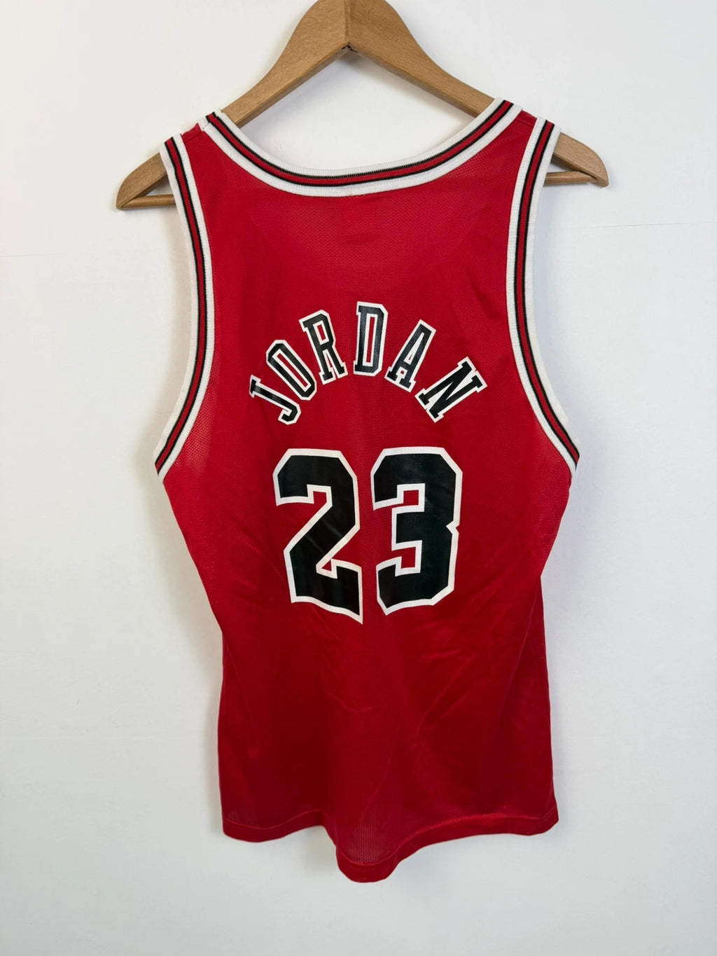 Champion red graphic tee featuring Jordan appliqué, NBA logo embroidery, and ribbed trim.