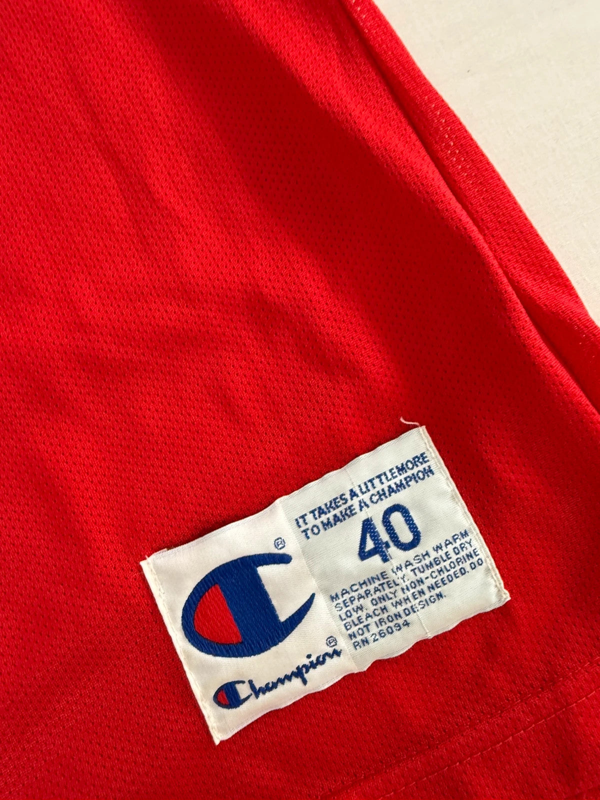 Champion red graphic tee featuring Jordan appliqué, NBA logo embroidery, and ribbed trim.