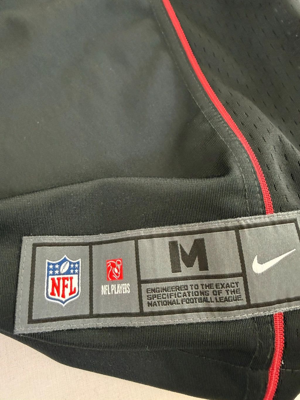 Nike graphic tee black with Arizona Cardinals logo, red and white piping, and NFL shield.