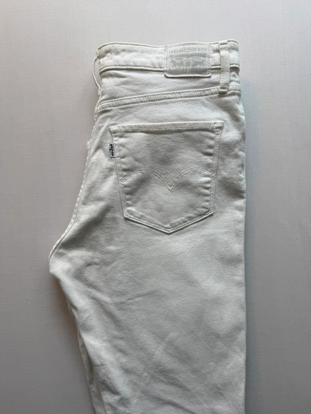 Levi's white high rise skinny jeans with five-pocket styling and zip fly.
