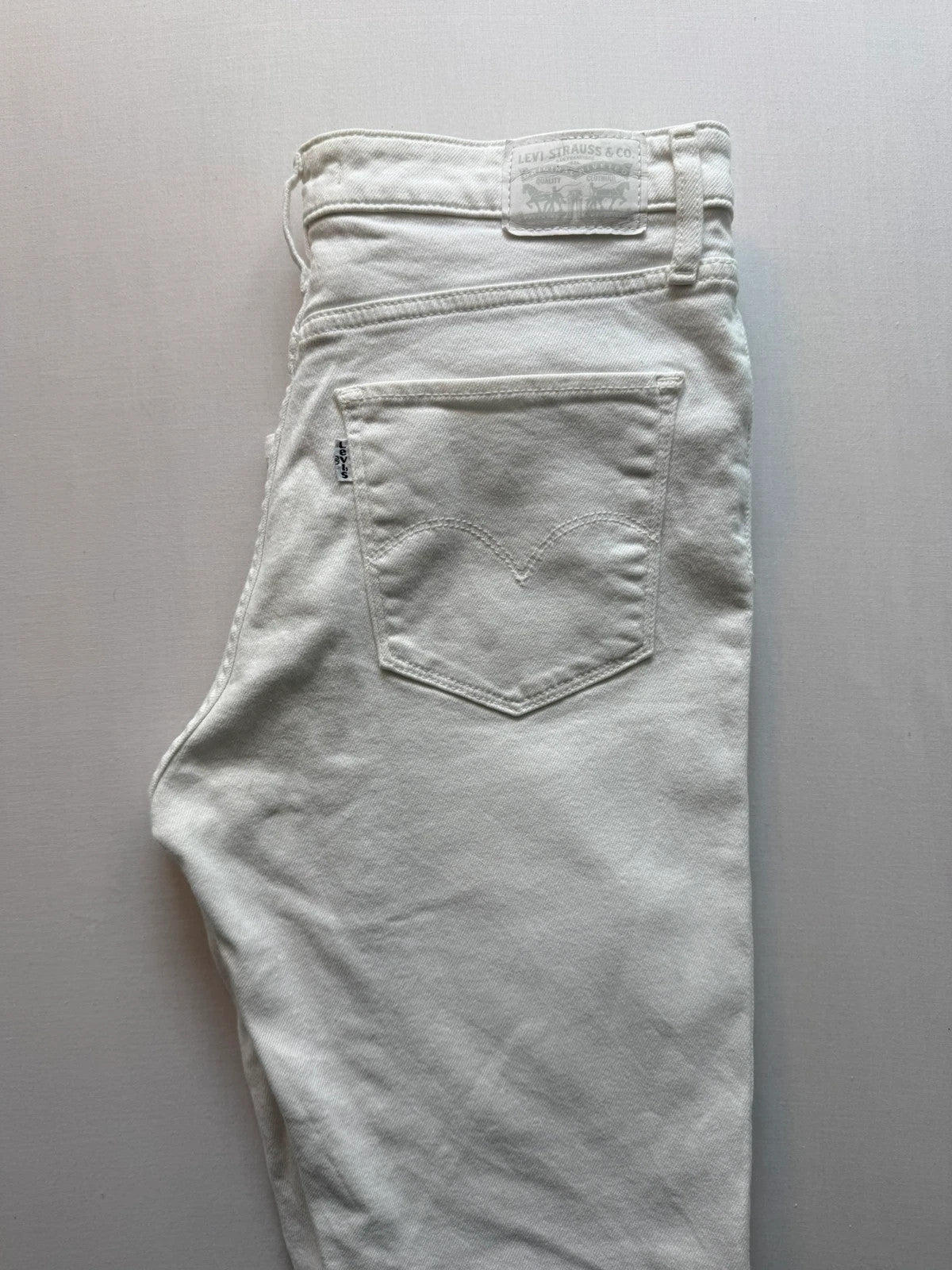 Levi's white high rise skinny jeans with five-pocket styling and zip fly.