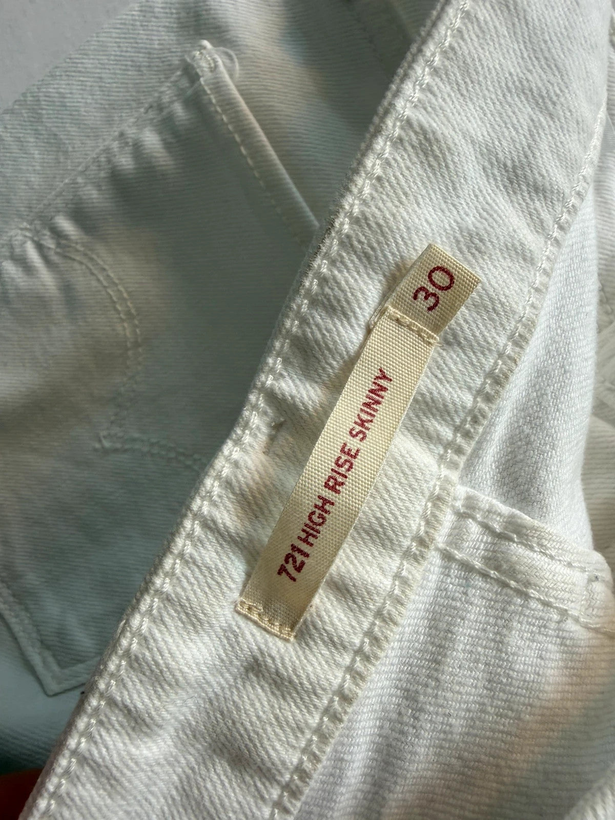 Levi's white high rise skinny jeans with five-pocket styling and zip fly.
