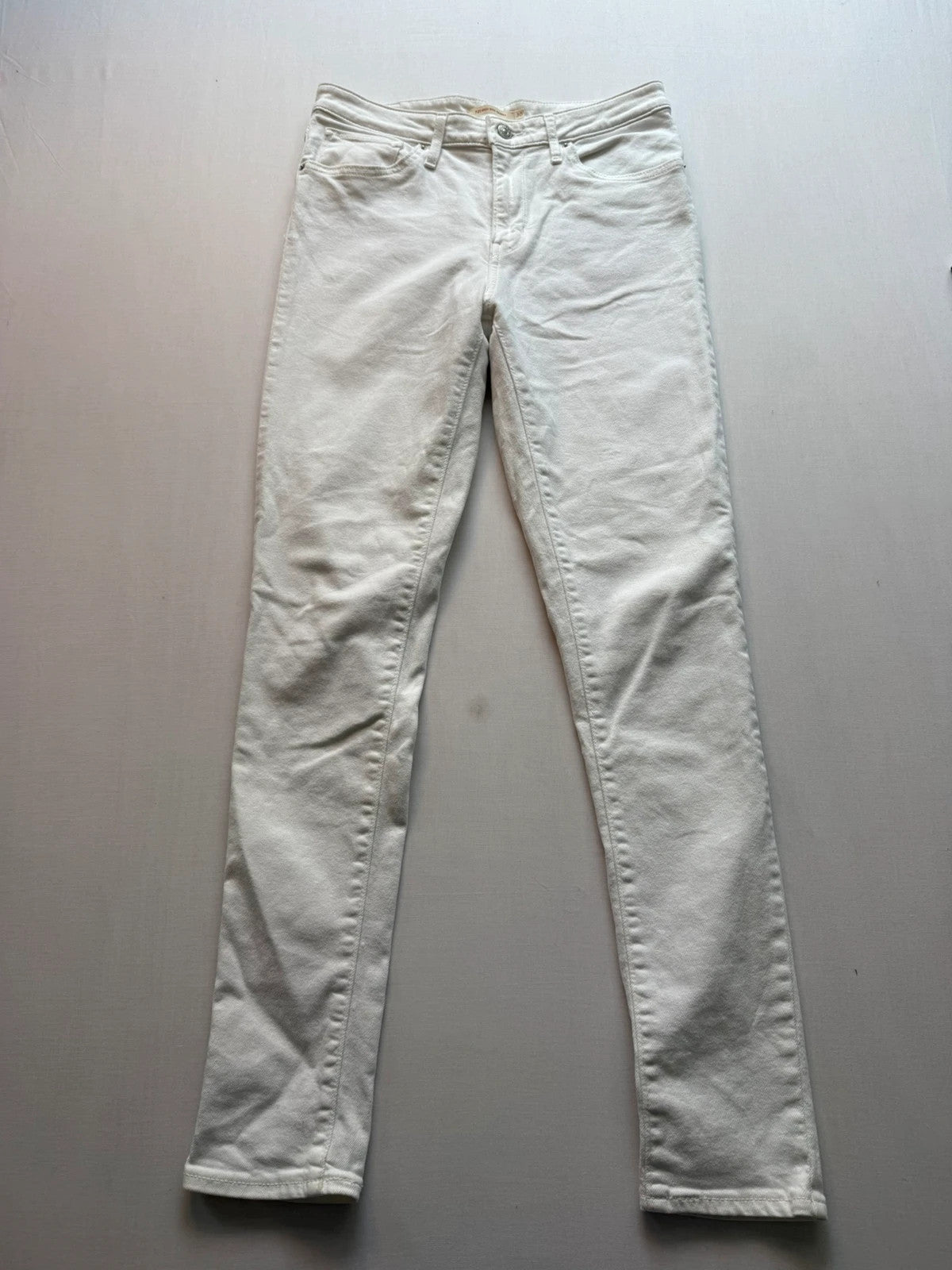 Levi's white high rise skinny jeans with five-pocket styling and zip fly.