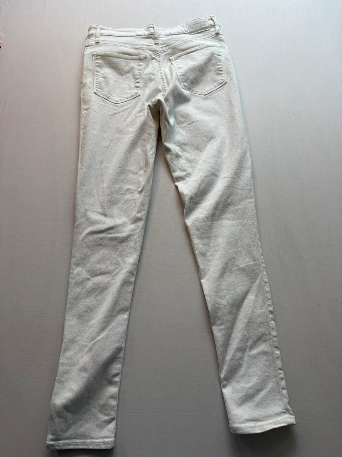 Levi's white high rise skinny jeans with five-pocket styling and zip fly.