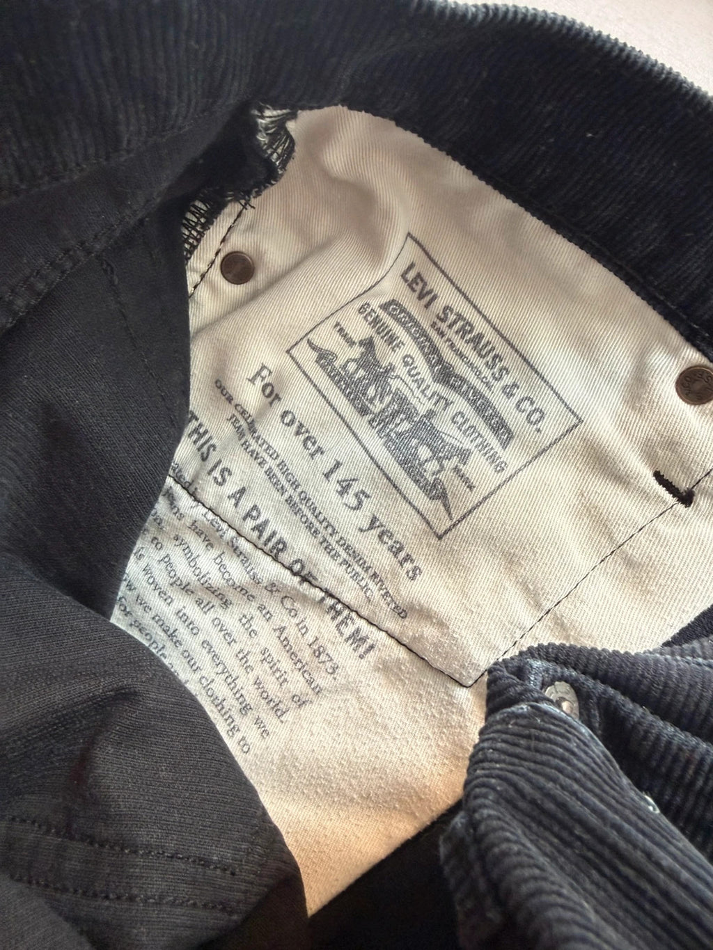 Levi's black straight jeans with classic five-pocket styling and signature back pocket stitching.