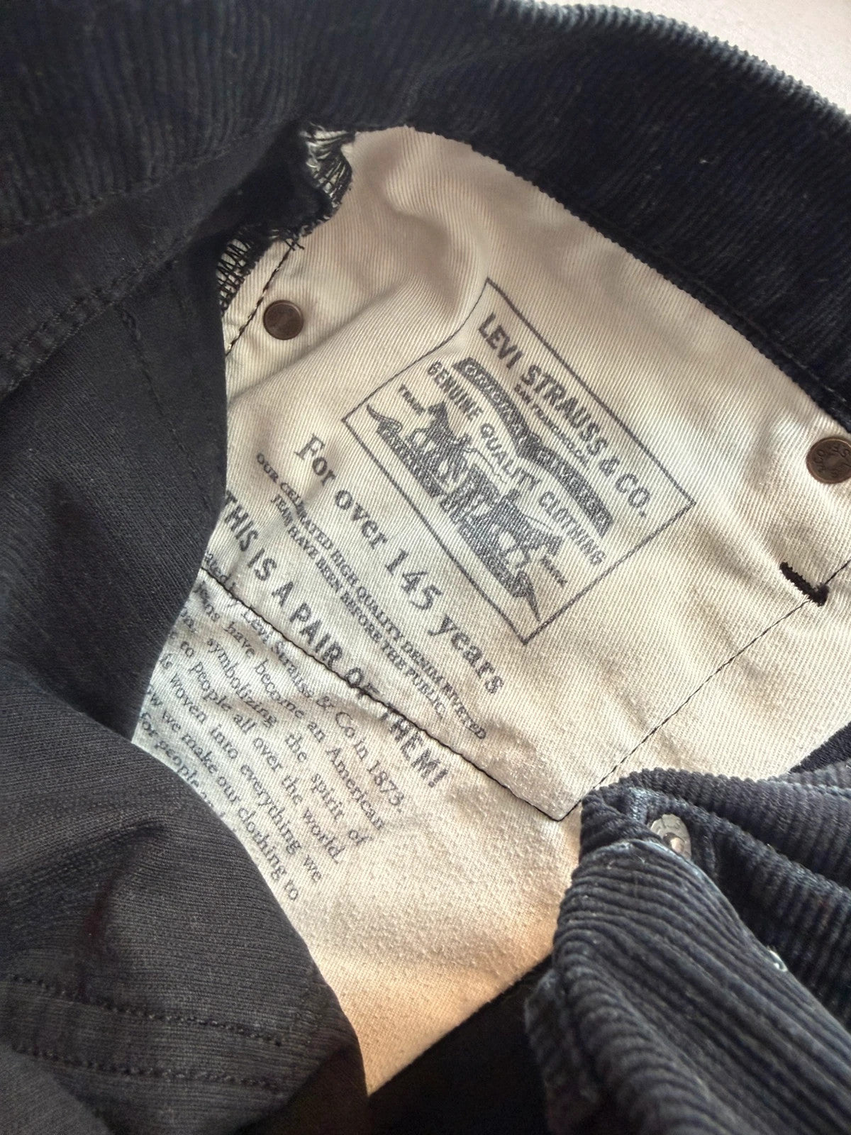 Levi's black straight jeans with classic five-pocket styling and signature back pocket stitching.