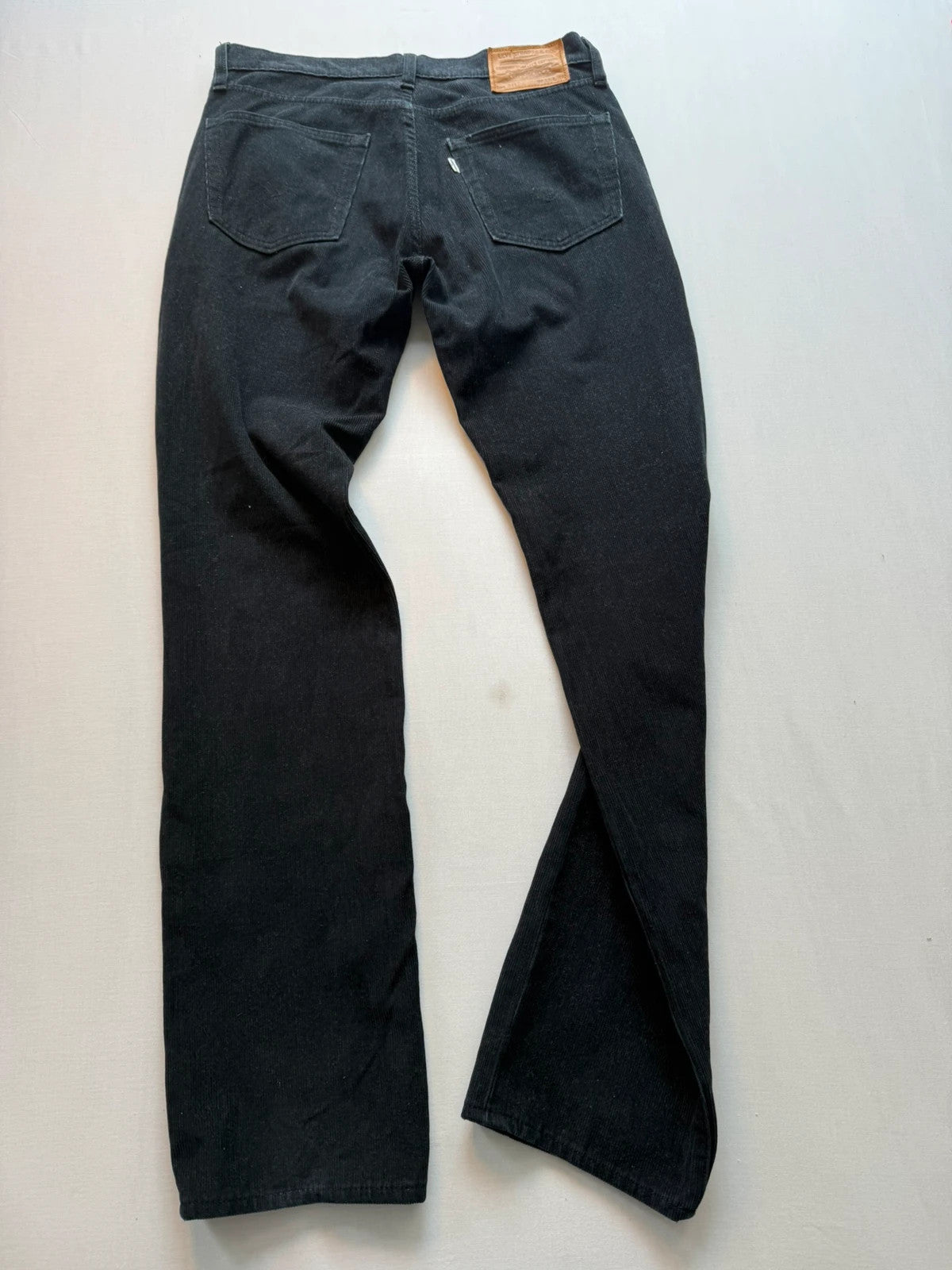 Levi's black straight jeans with classic five-pocket styling and signature back pocket stitching.