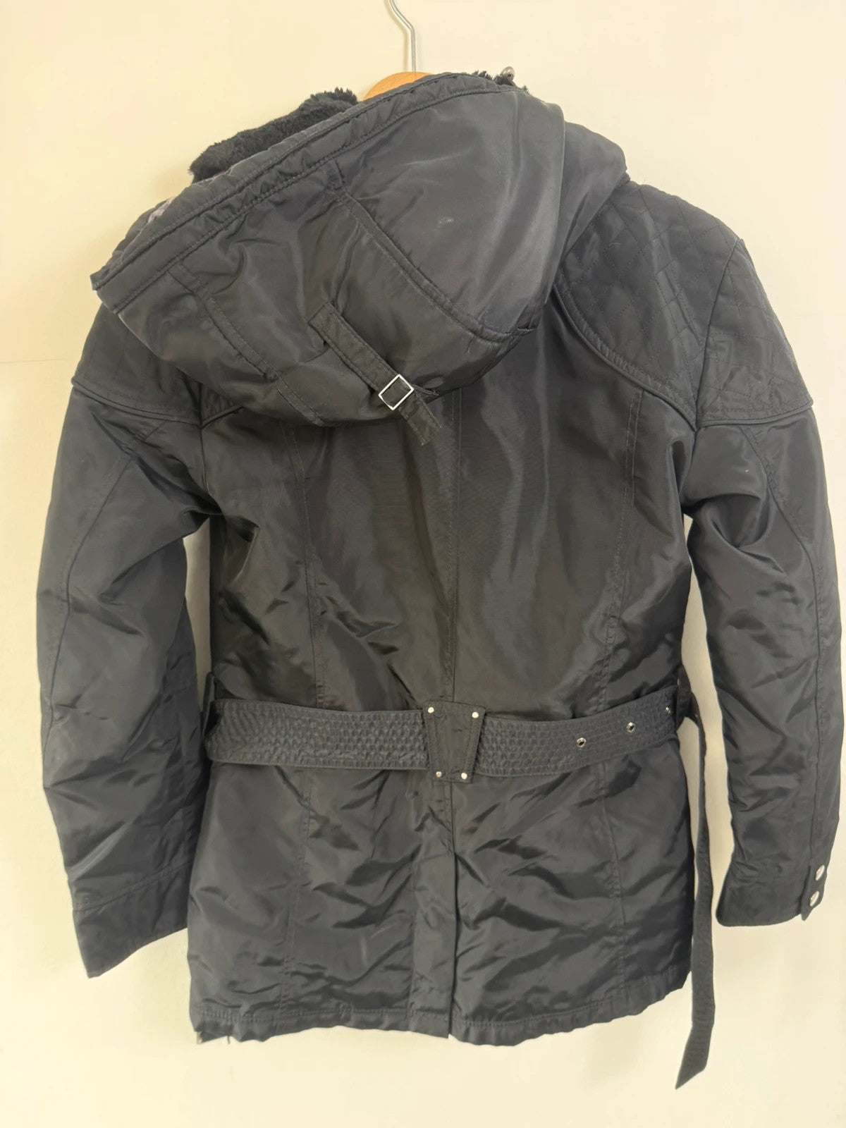 Barbour black waterproof jacket with faux fur collar, quilted shoulder panels, and tartan lining.