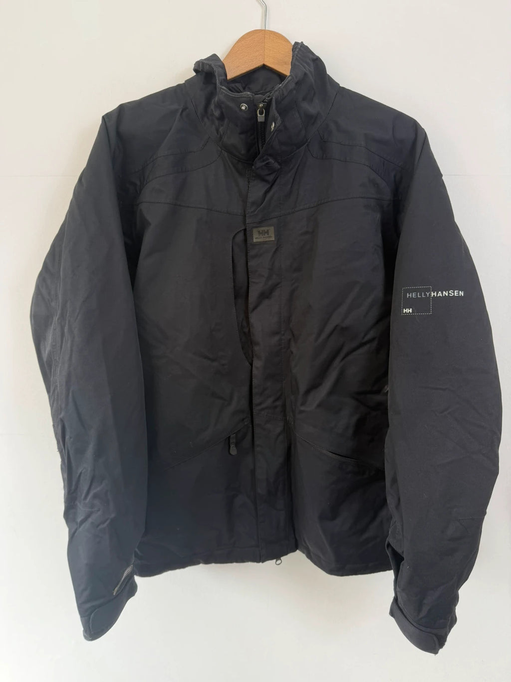 Helly Hansen black ski jacket with waterproof shell, mesh-vented pockets, and adjustable cuffs.