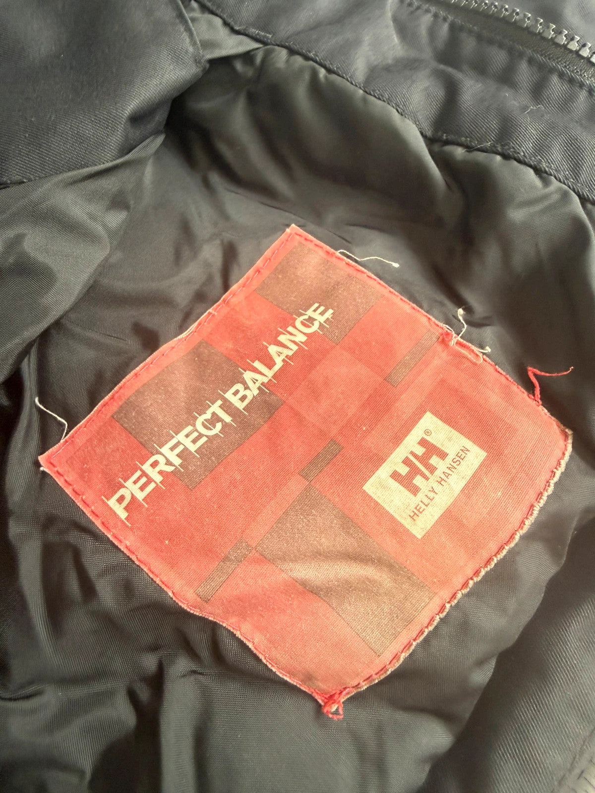Helly Hansen black ski jacket with waterproof shell, mesh-vented pockets, and adjustable cuffs.