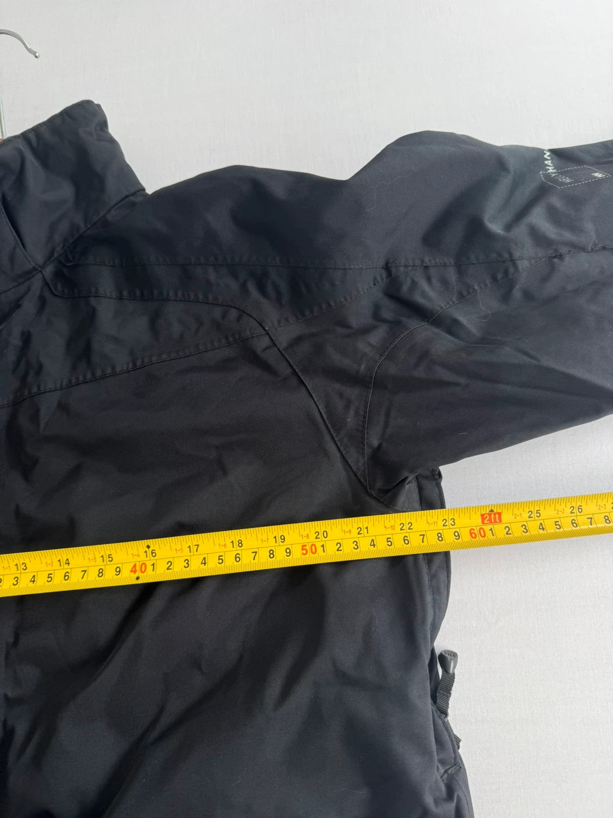Helly Hansen black ski jacket with waterproof shell, mesh-vented pockets, and adjustable cuffs.