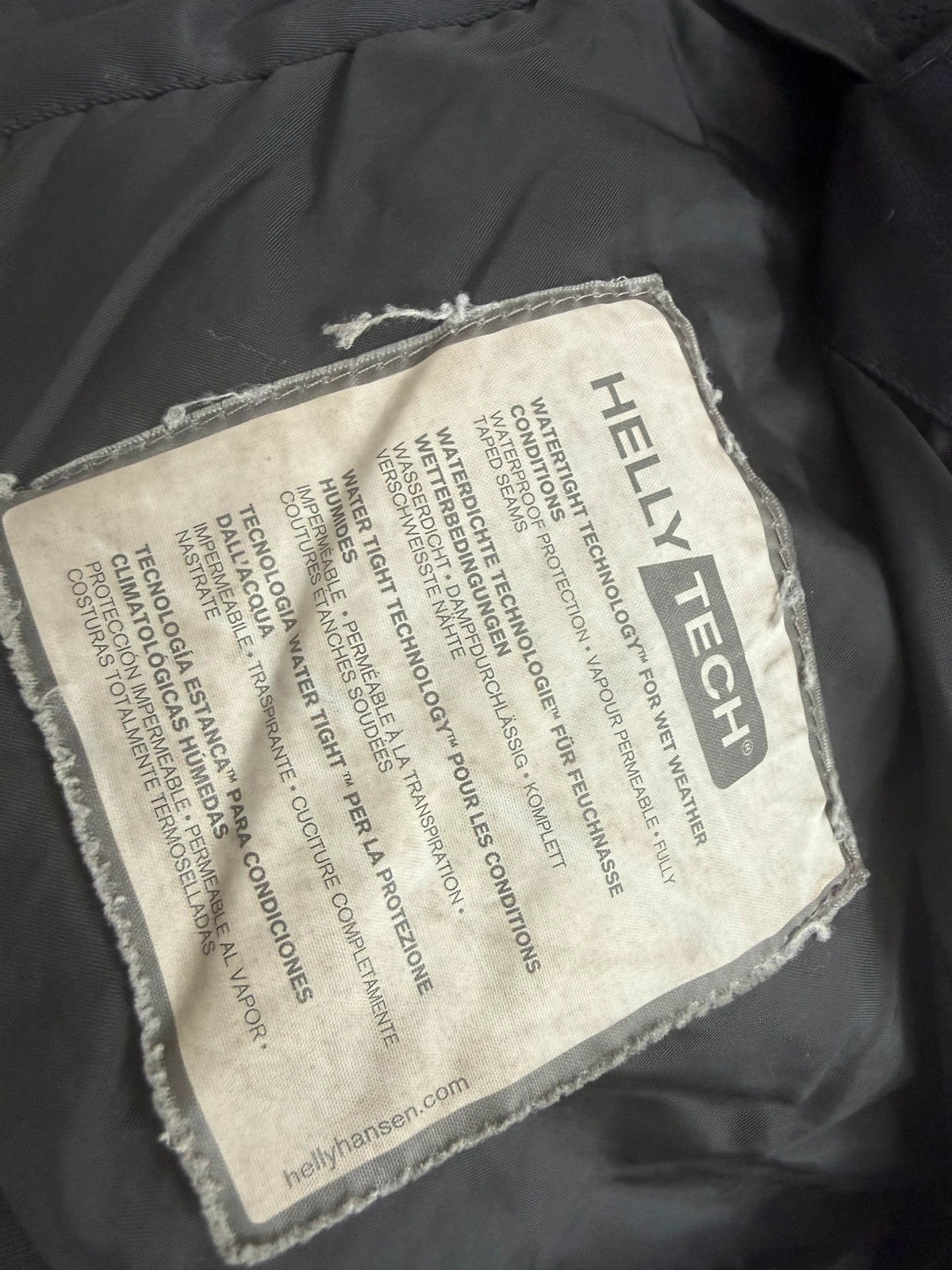 Helly Hansen black ski jacket with waterproof shell, mesh-vented pockets, and adjustable cuffs.