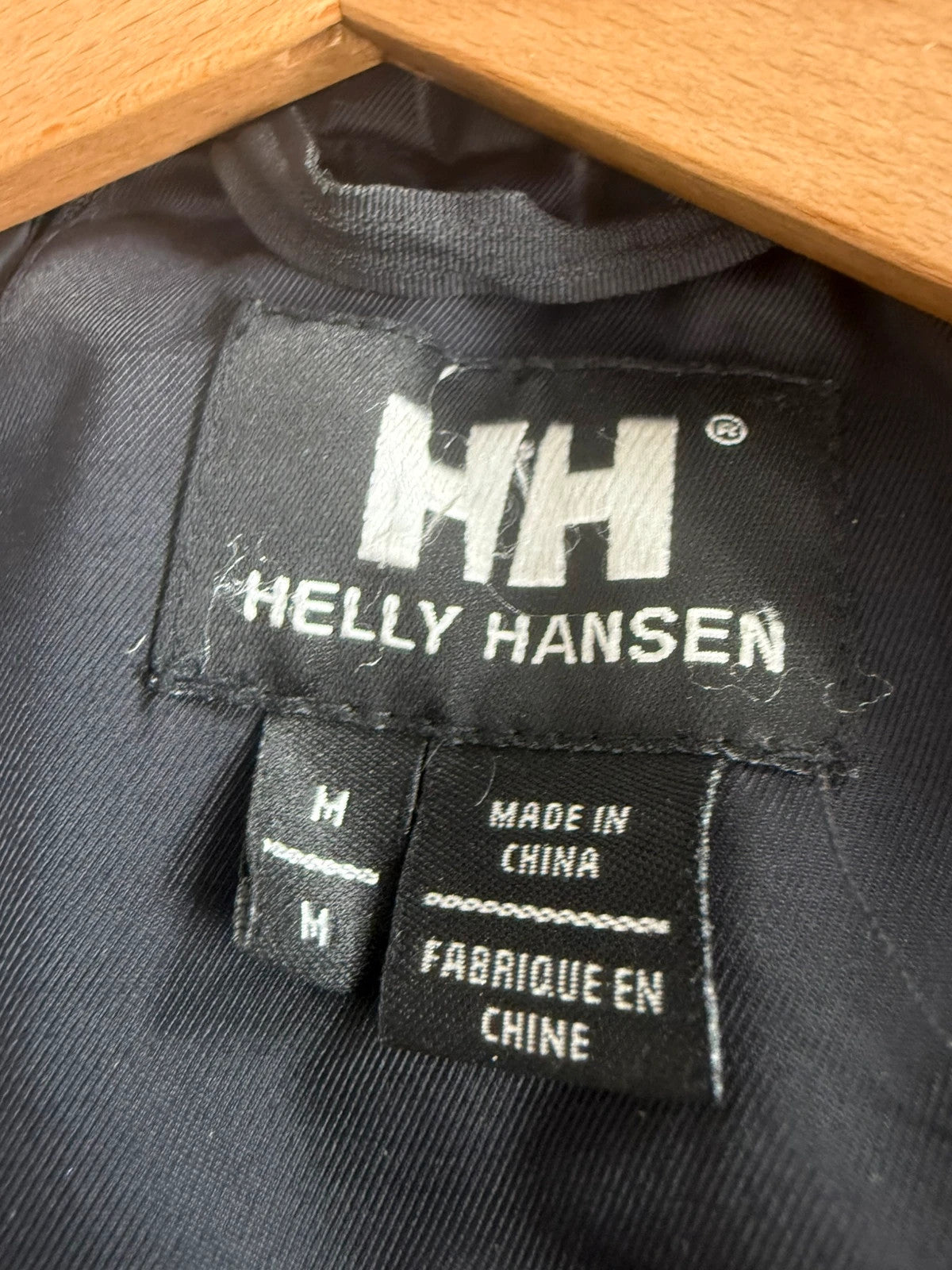 Helly Hansen black ski jacket with waterproof shell, mesh-vented pockets, and adjustable cuffs.