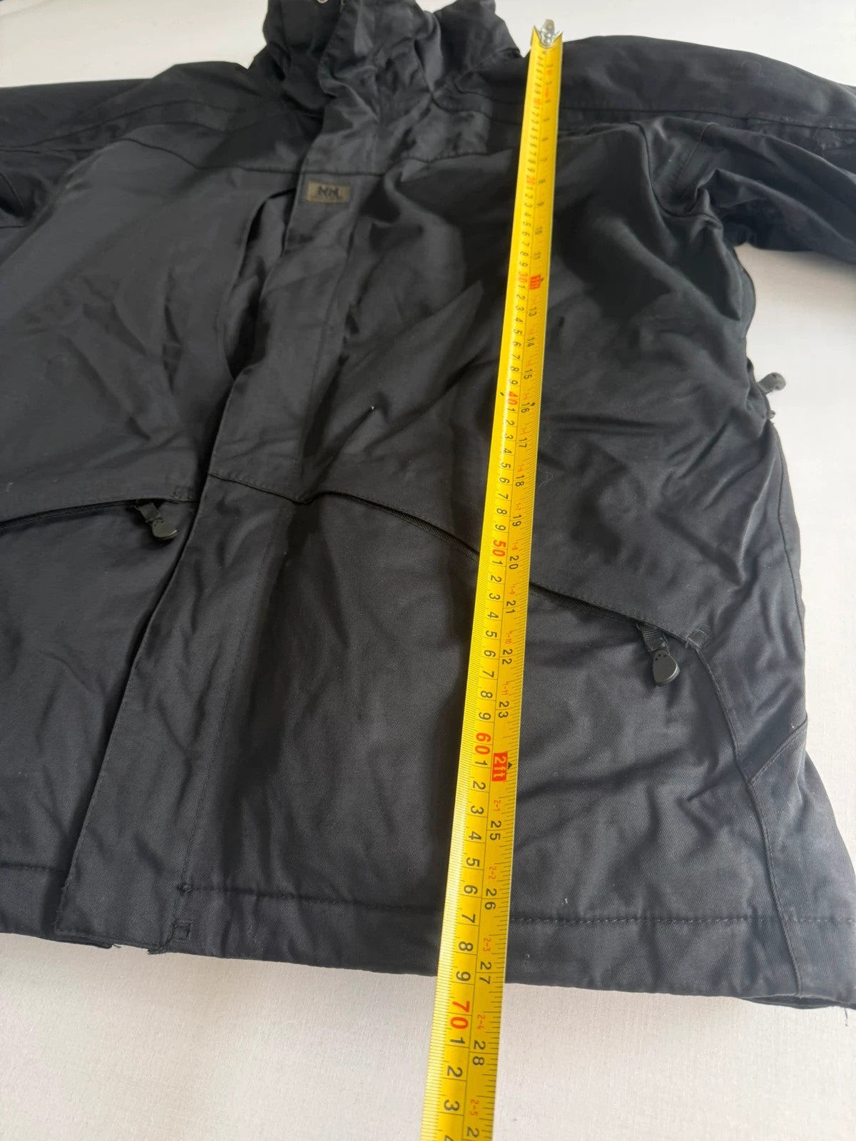 Helly Hansen black ski jacket with waterproof shell, mesh-vented pockets, and adjustable cuffs.