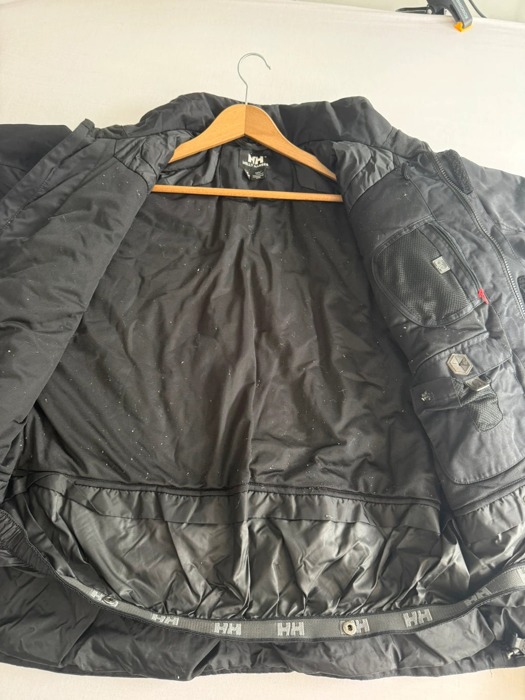 Helly Hansen black ski jacket with waterproof shell, mesh-vented pockets, and adjustable cuffs.