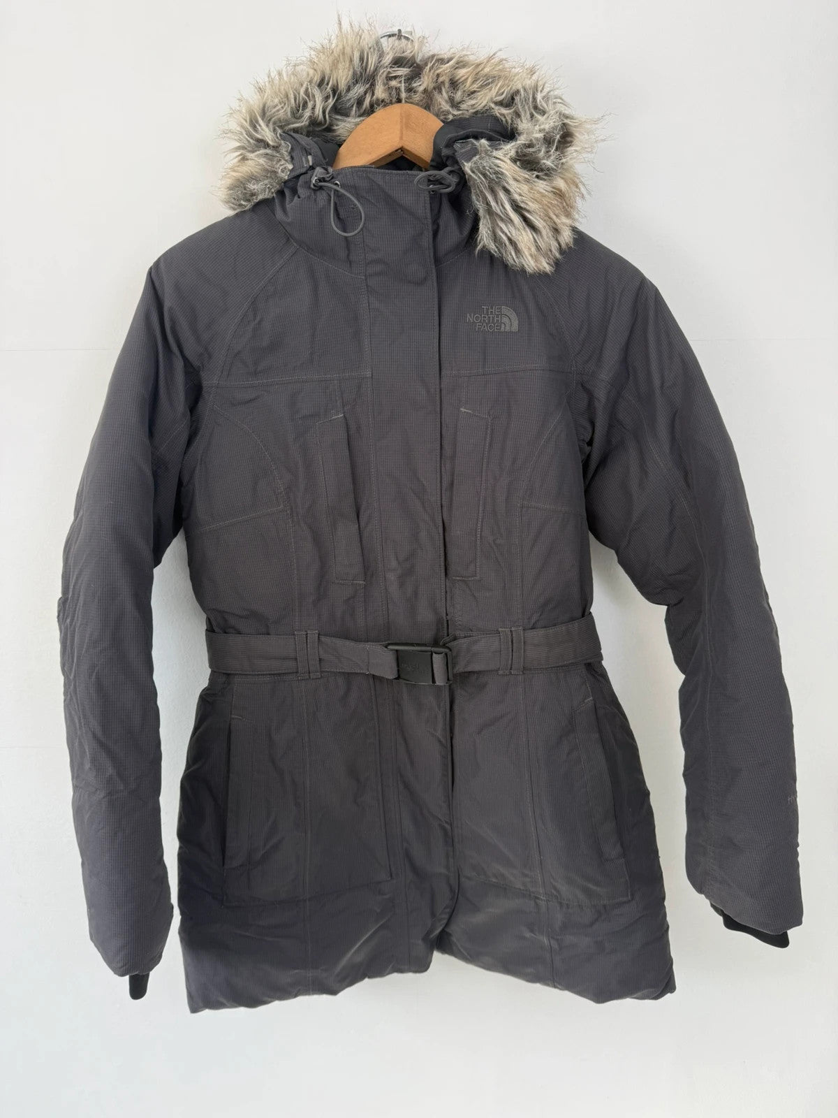 The North Face grey parka with adjustable faux fur hood and belted waist.