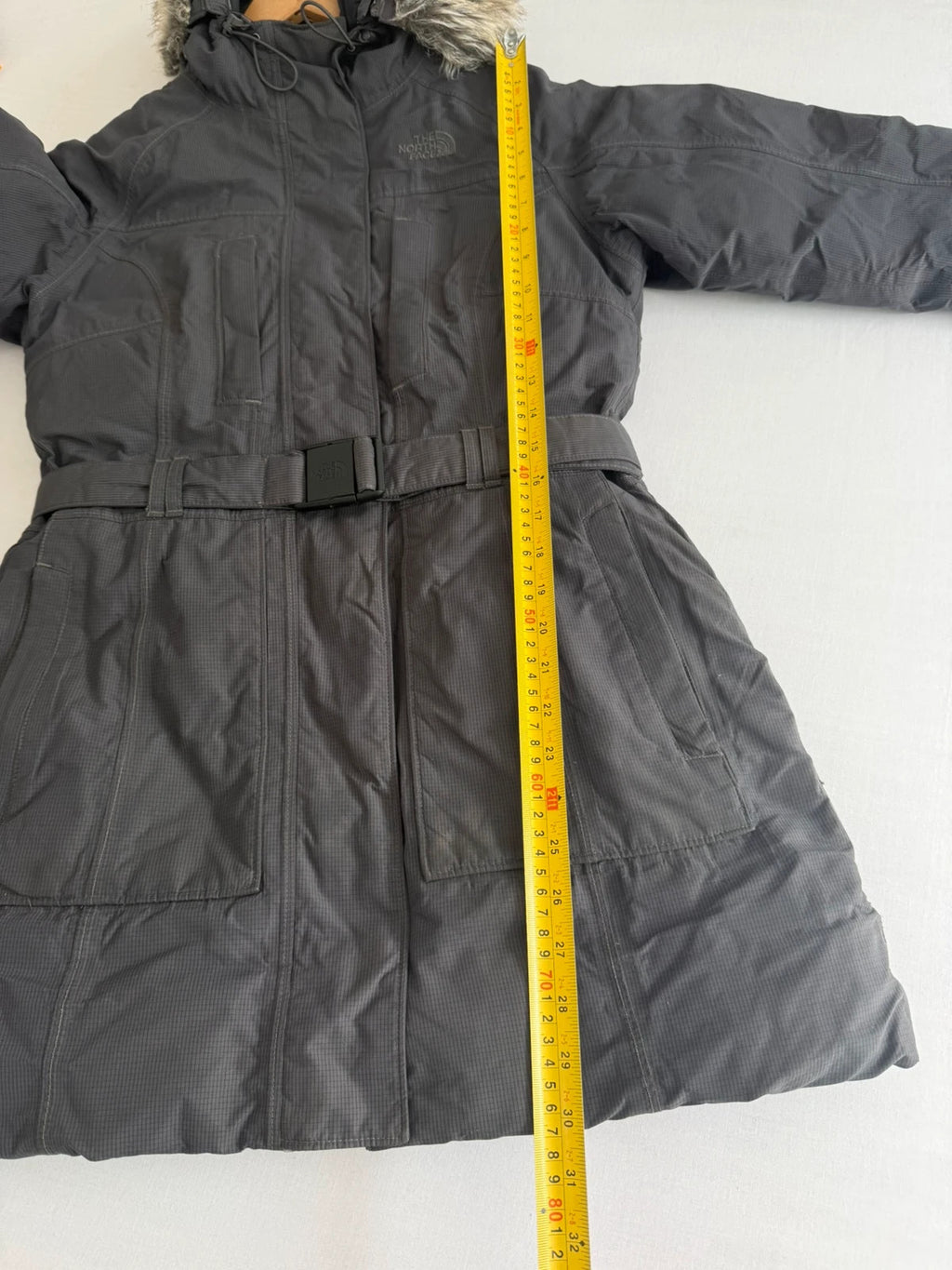 The North Face grey parka with adjustable faux fur hood and belted waist.
