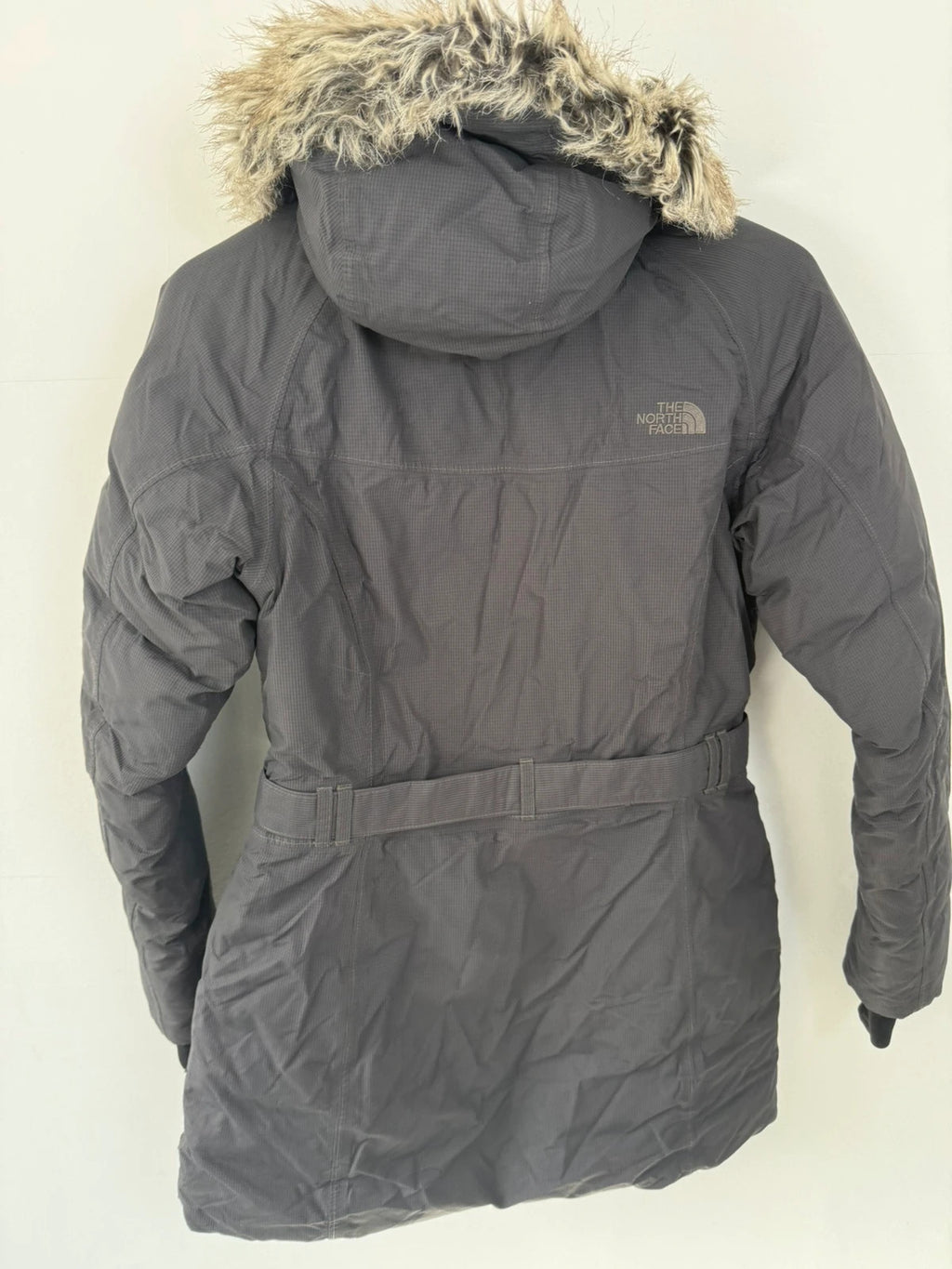 The North Face grey parka with adjustable faux fur hood and belted waist.