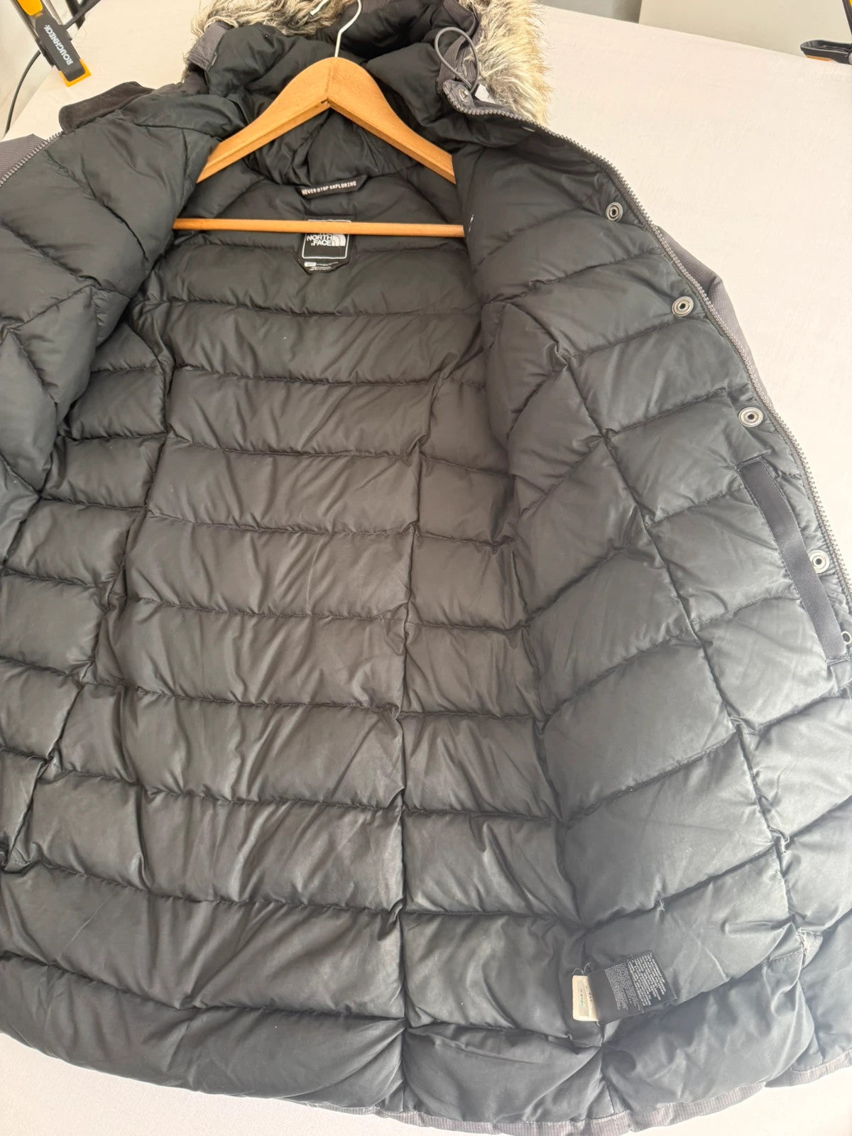 The North Face grey parka with adjustable faux fur hood and belted waist.