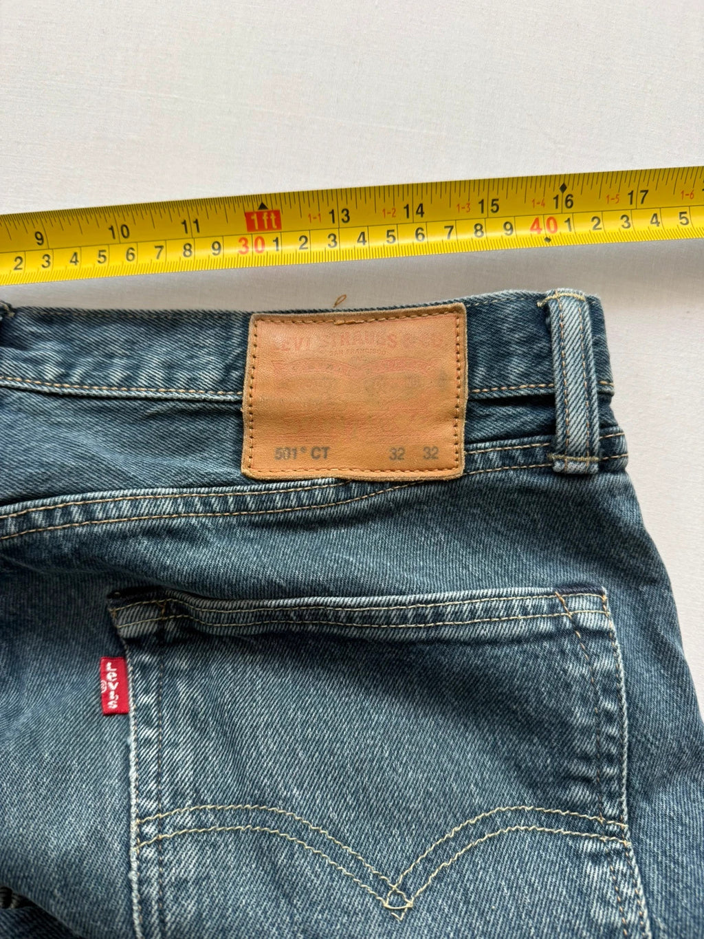 Levi's blue tapered jeans with classic 501 cut and subtle stretch detail.