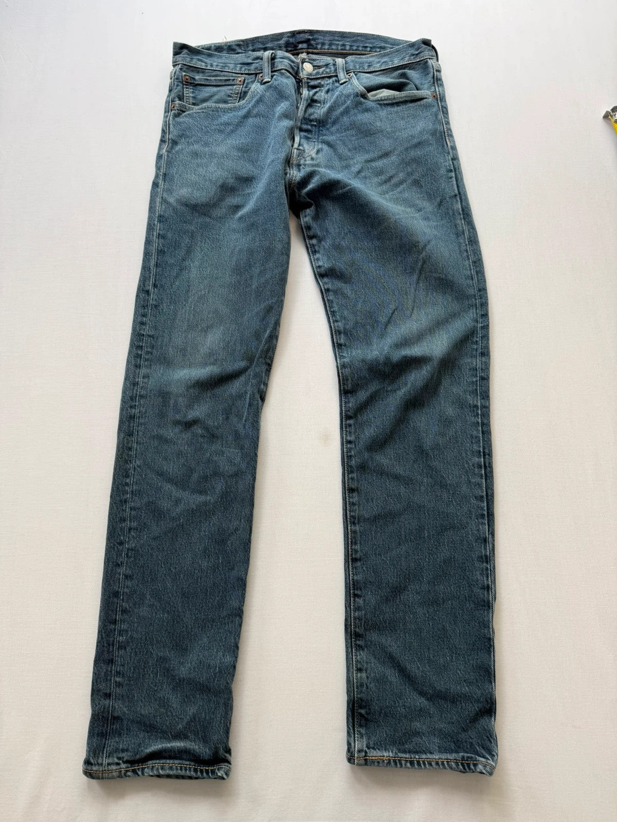Levi's blue tapered jeans with classic 501 cut and subtle stretch detail.