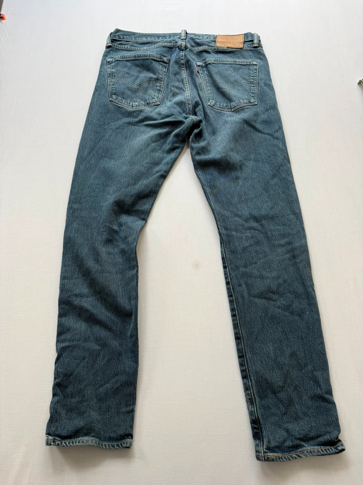 Levi's blue tapered jeans with classic 501 cut and subtle stretch detail.