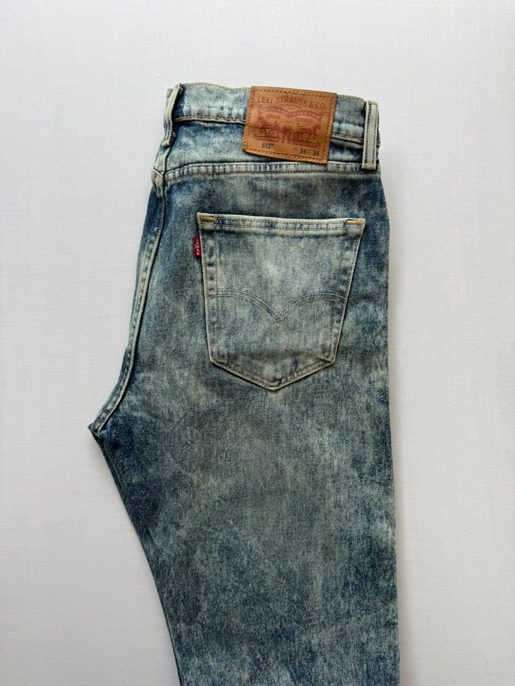 Levi's light blue acid wash tapered jeans with classic five-pocket styling and leather patch.