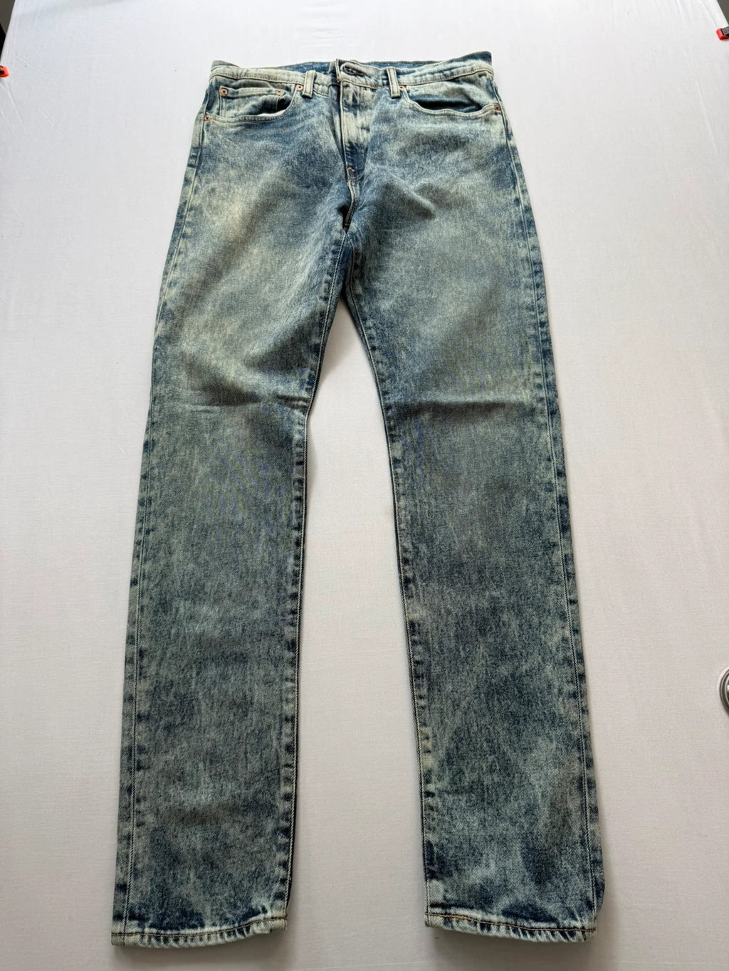 Levi's light blue acid wash tapered jeans with classic five-pocket styling and leather patch.