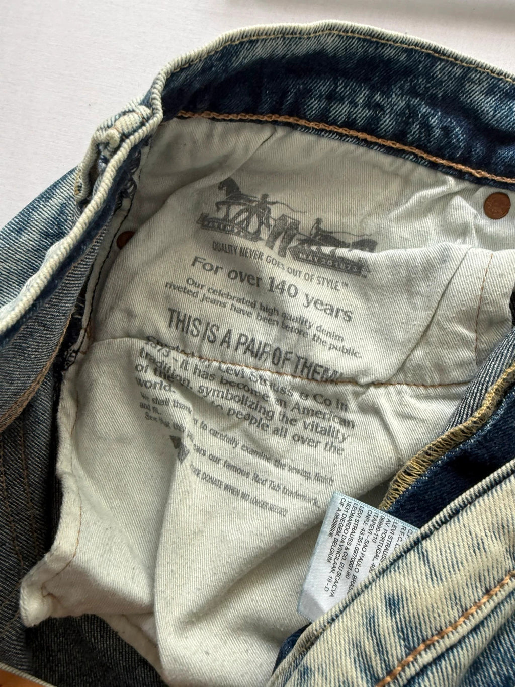 Levi's light blue acid wash tapered jeans with classic five-pocket styling and leather patch.
