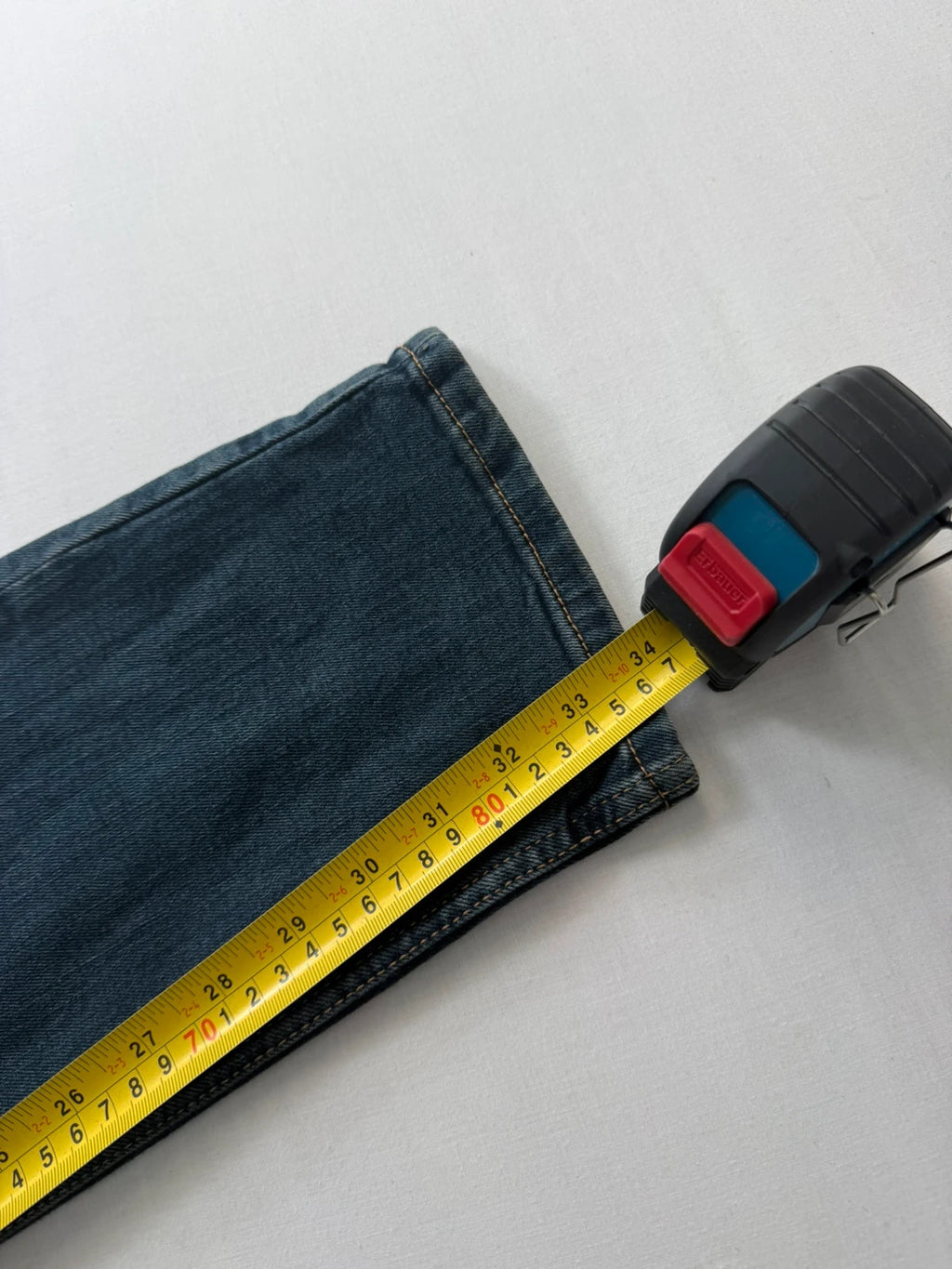 Levi's navy slim tapered jeans with faded blue-grey wash and signature back stitching.