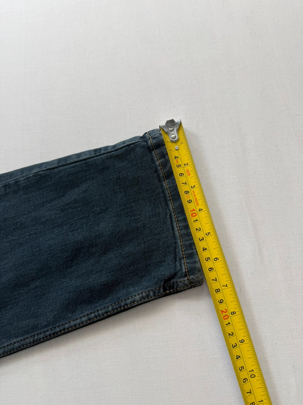 Levi's navy slim tapered jeans with faded blue-grey wash and signature back stitching.