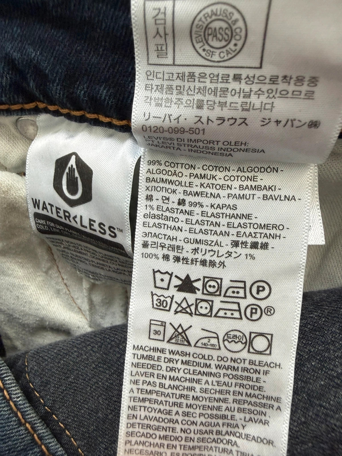 Levi's navy slim tapered jeans with faded blue-grey wash and signature back stitching.