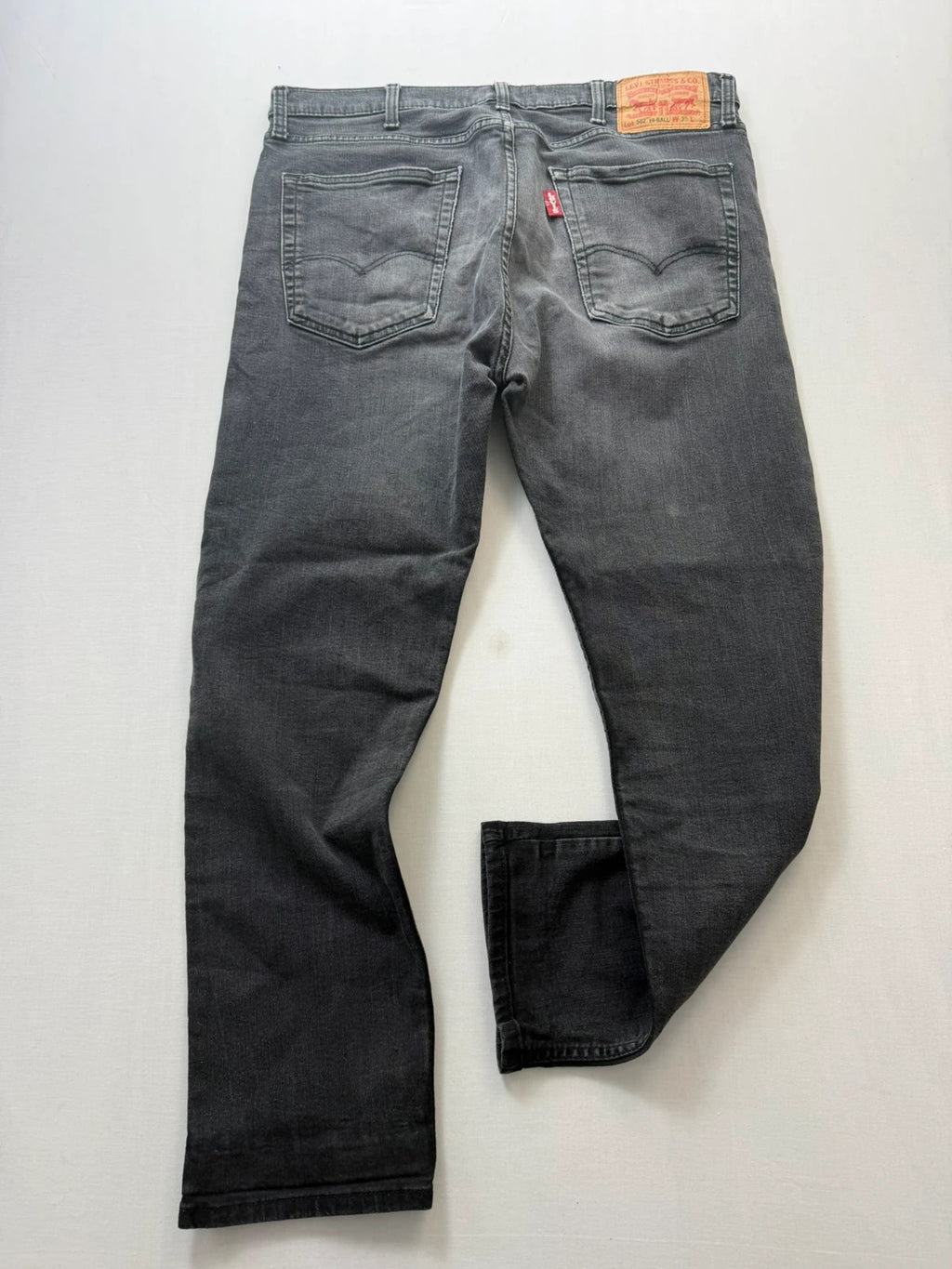 Levi's grey tapered jeans with classic 5-pocket styling and signature back stitching.
