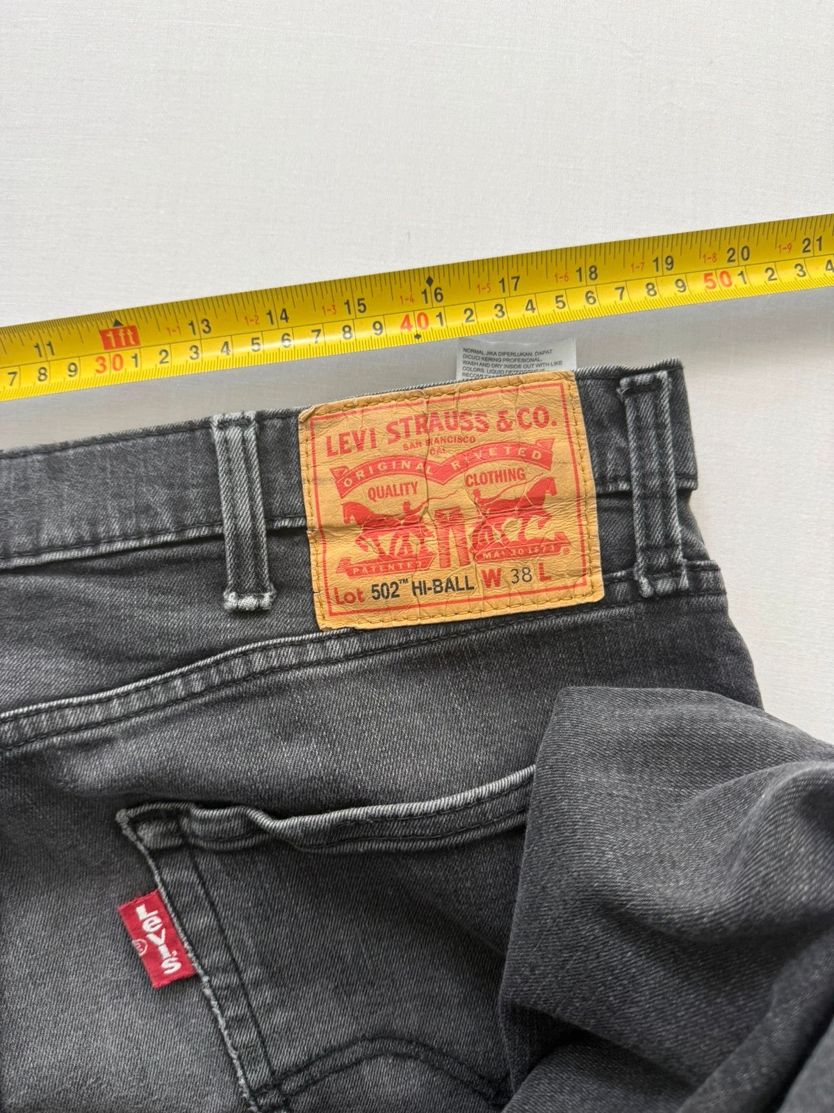 Levi's grey tapered jeans with classic 5-pocket styling and signature back stitching.