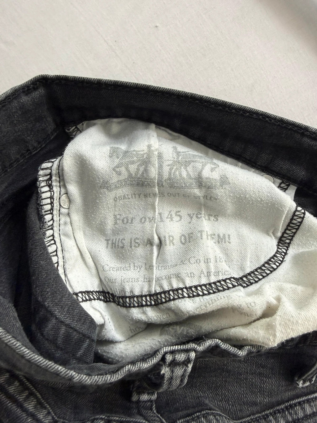 Levi's grey tapered jeans with classic 5-pocket styling and signature back stitching.