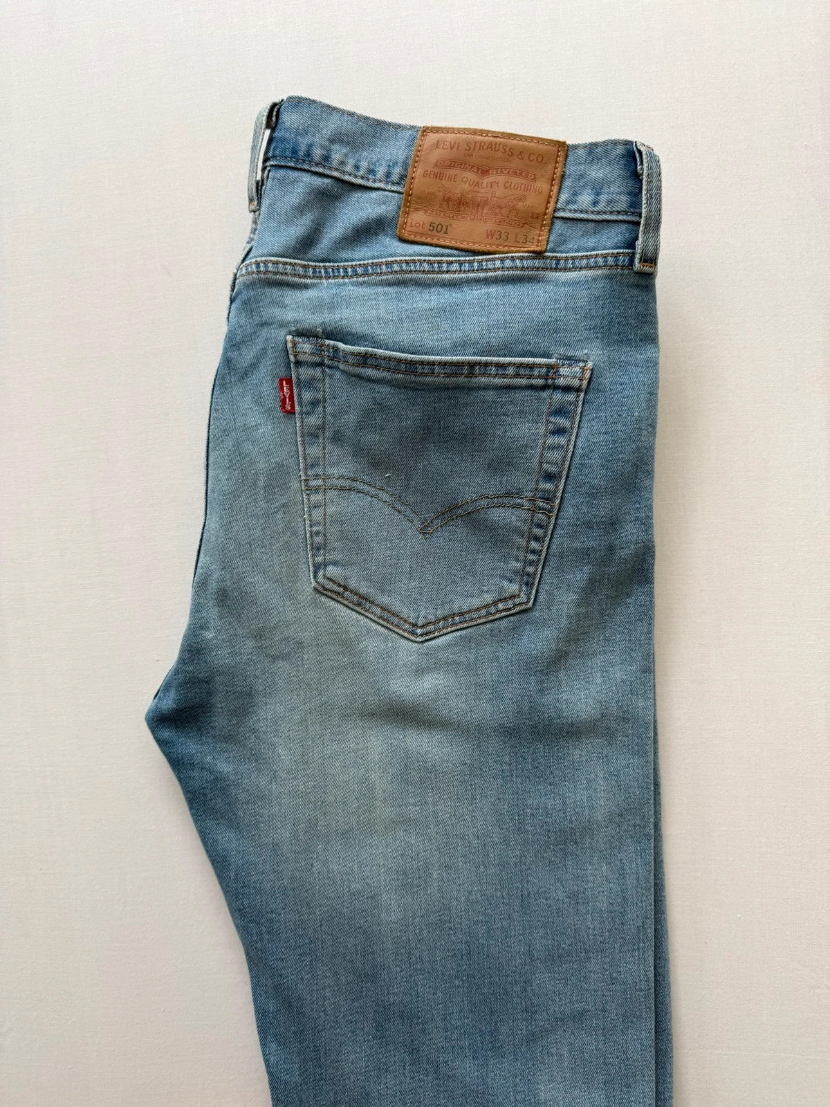 Levi's blue straight jeans with natural fading, 5-pocket styling, and back arcuate stitching.