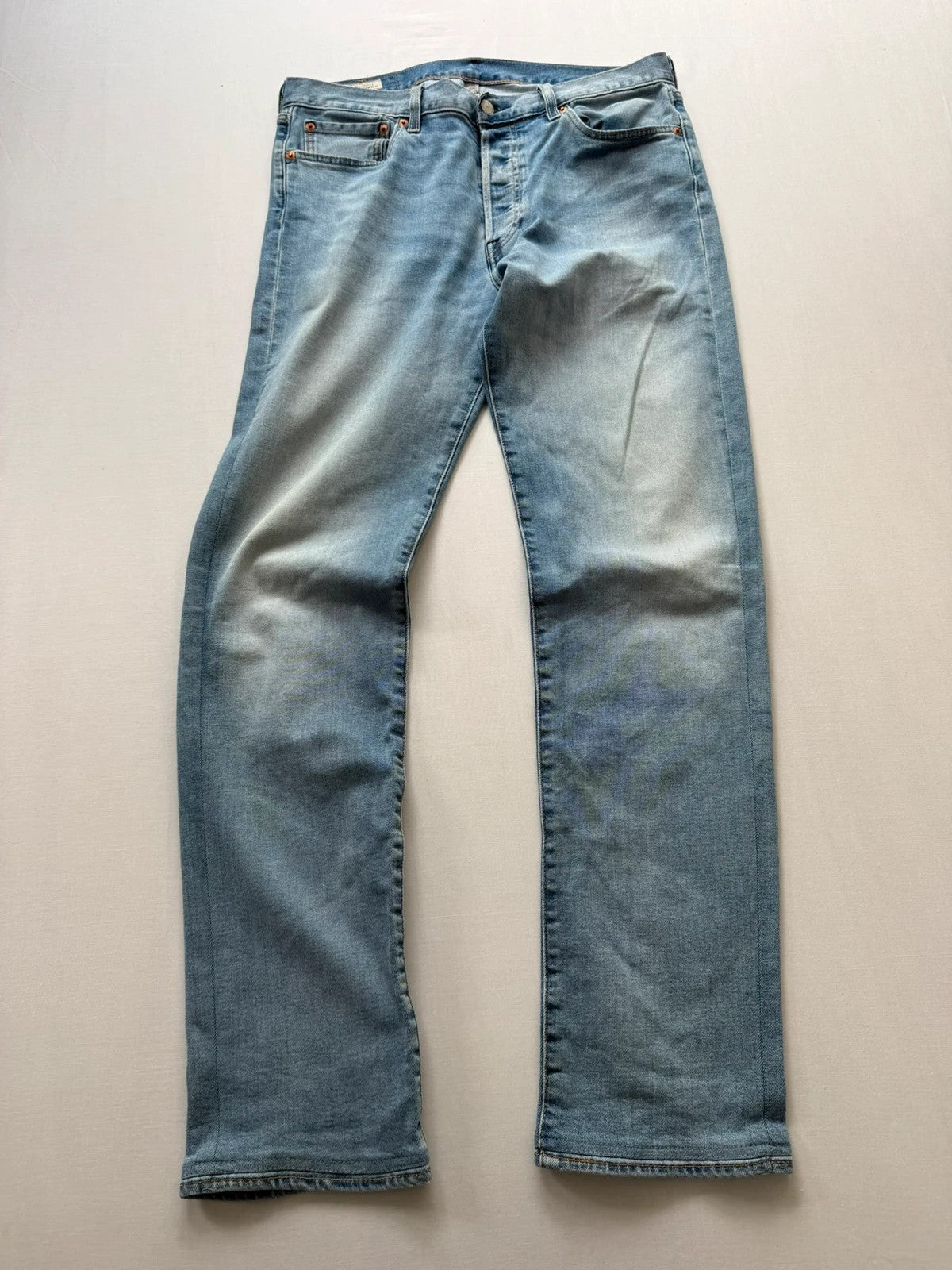 Levi's blue straight jeans with natural fading, 5-pocket styling, and back arcuate stitching.