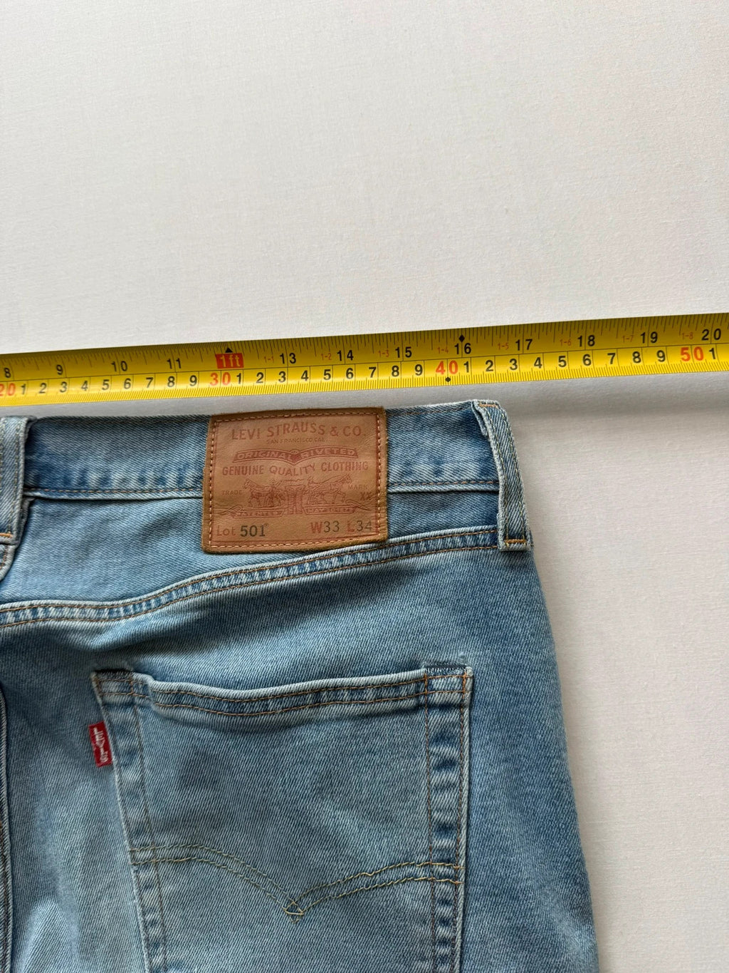 Levi's blue straight jeans with natural fading, 5-pocket styling, and back arcuate stitching.