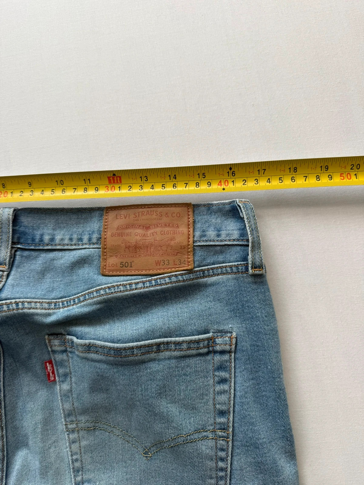 Levi's blue straight jeans with natural fading, 5-pocket styling, and back arcuate stitching.