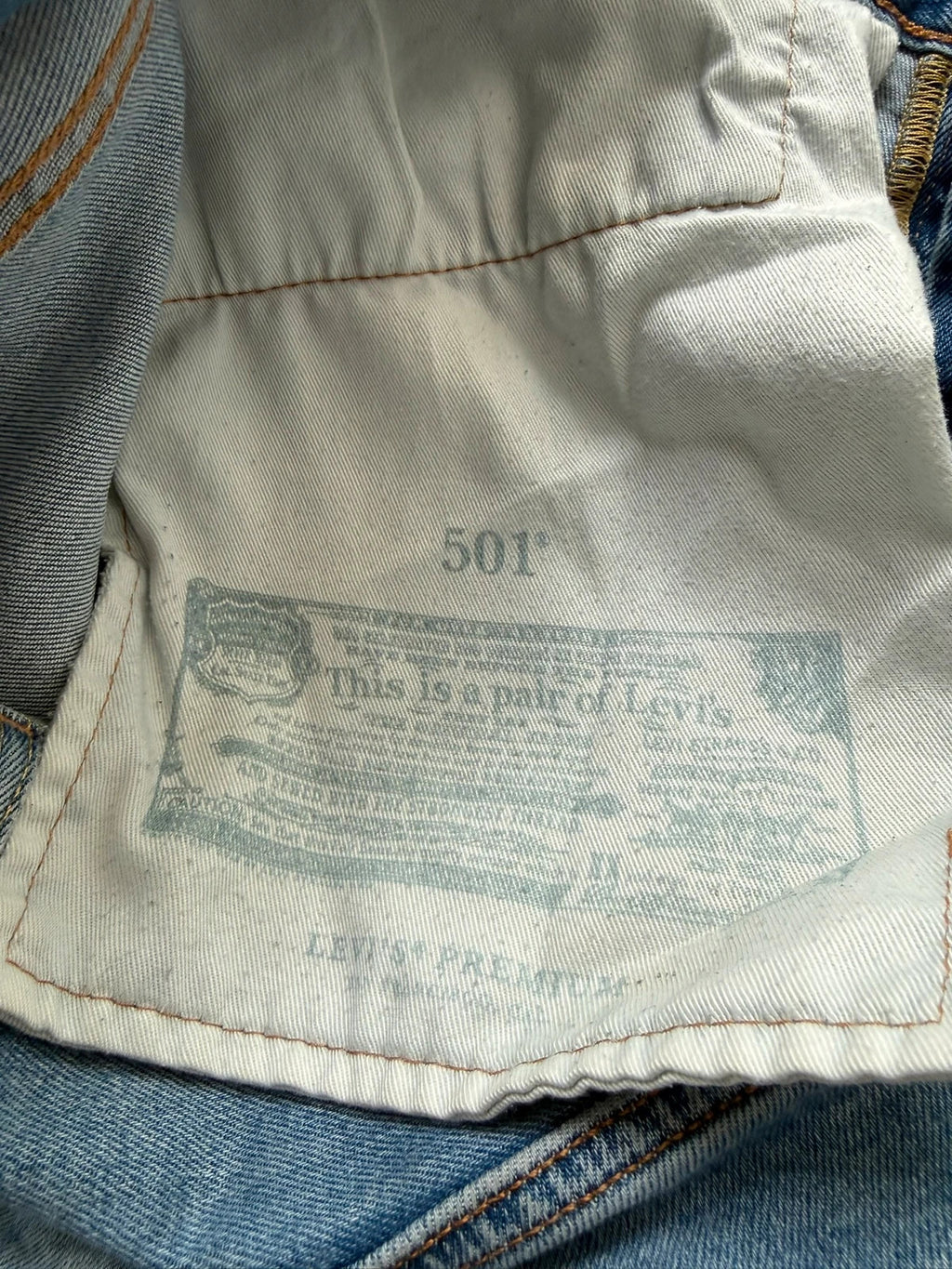 Levi's blue straight jeans with natural fading, 5-pocket styling, and back arcuate stitching.