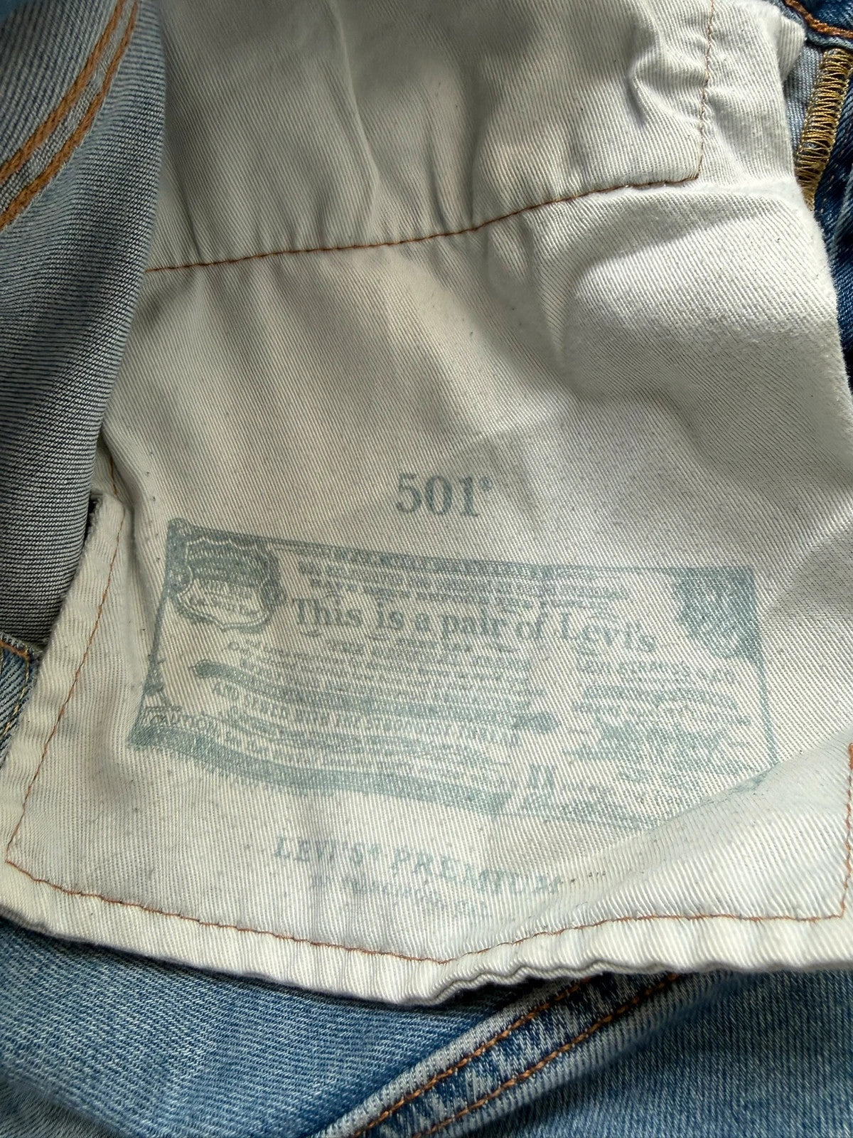 Levi's blue straight jeans with natural fading, 5-pocket styling, and back arcuate stitching.