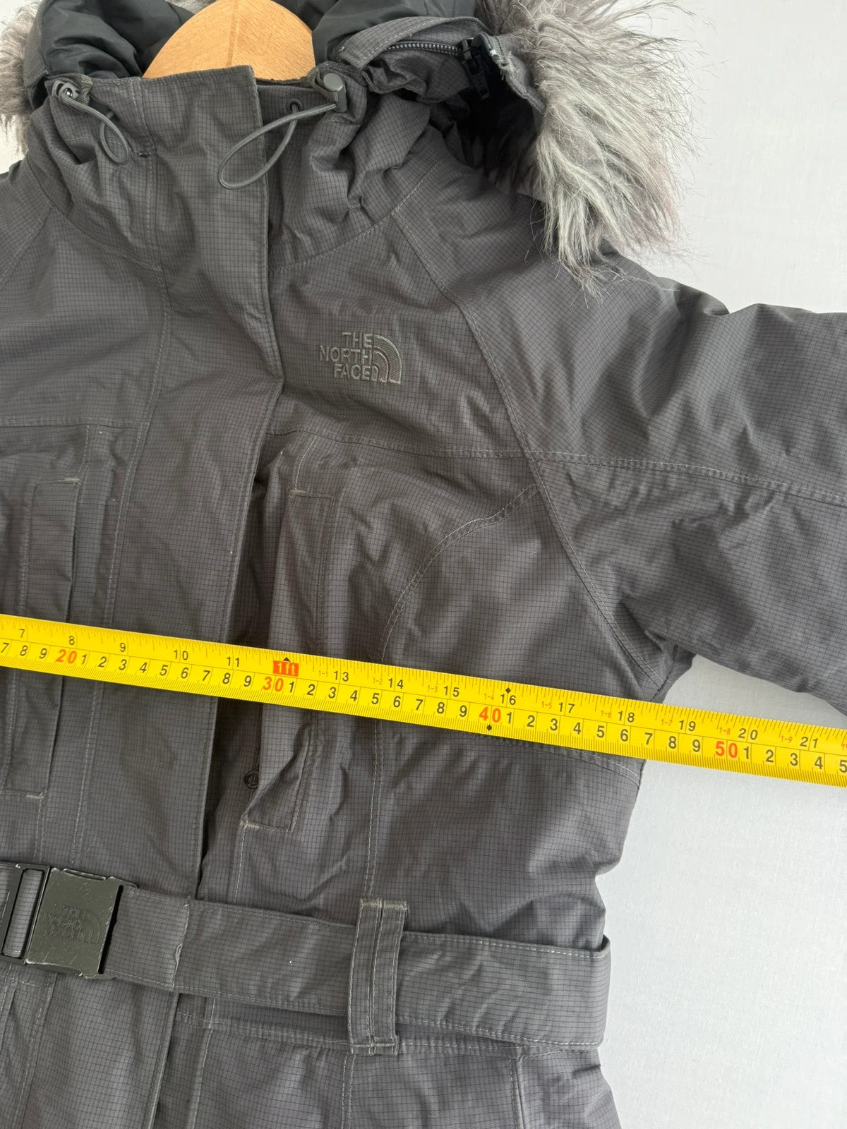 The North Face grey down parka with detachable faux fur hood and multiple pockets.