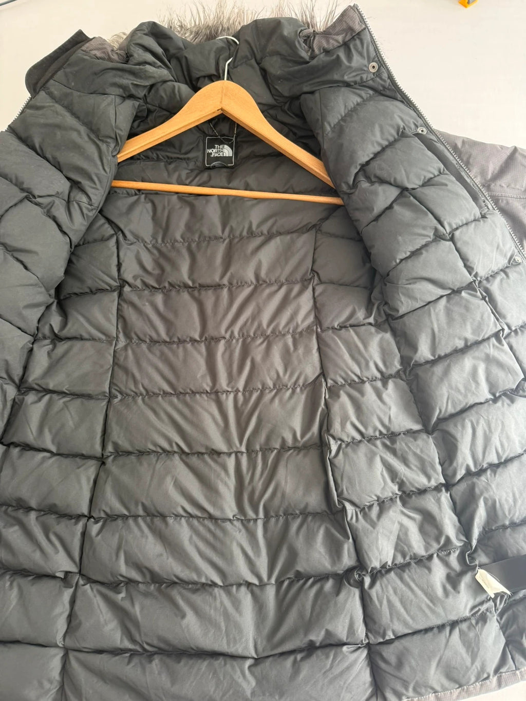 The North Face grey down parka with detachable faux fur hood and multiple pockets.