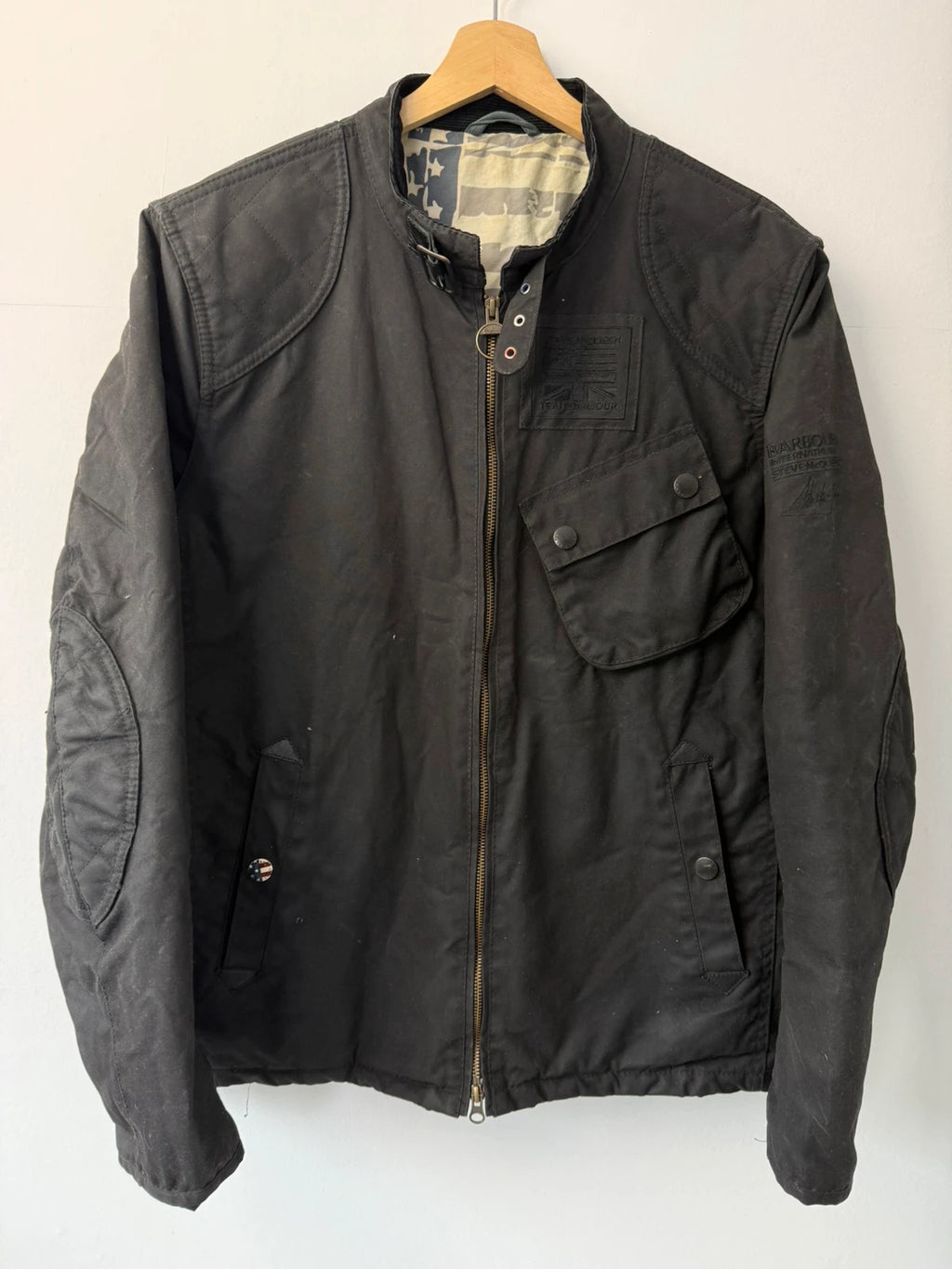 Barbour black waxed cotton biker jacket with embroidered Team Barbour patch and American flag lining.