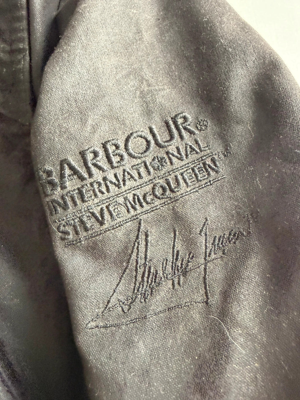 Barbour black waxed cotton biker jacket with embroidered Team Barbour patch and American flag lining.