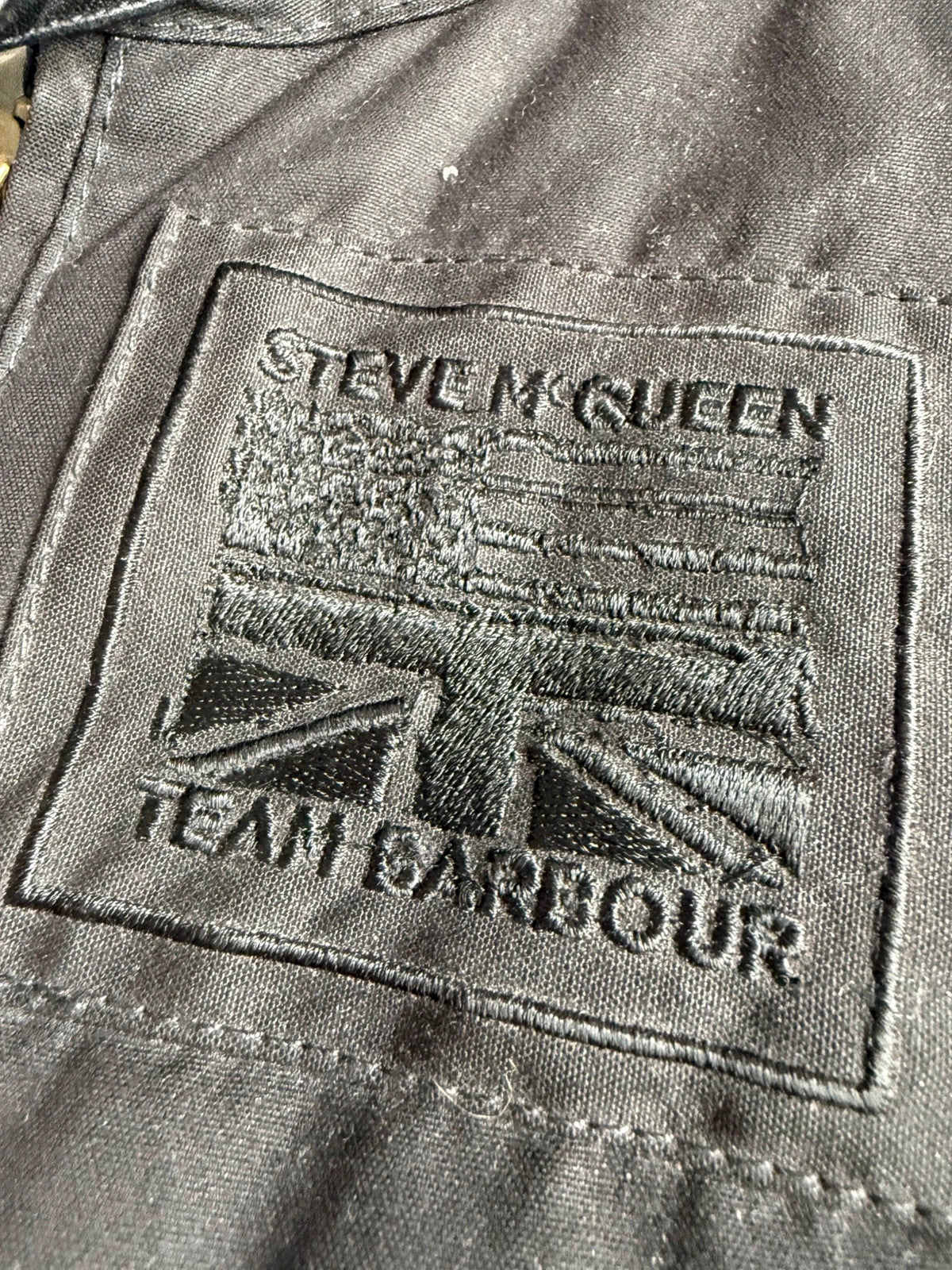Barbour black waxed cotton biker jacket with embroidered Team Barbour patch and American flag lining.