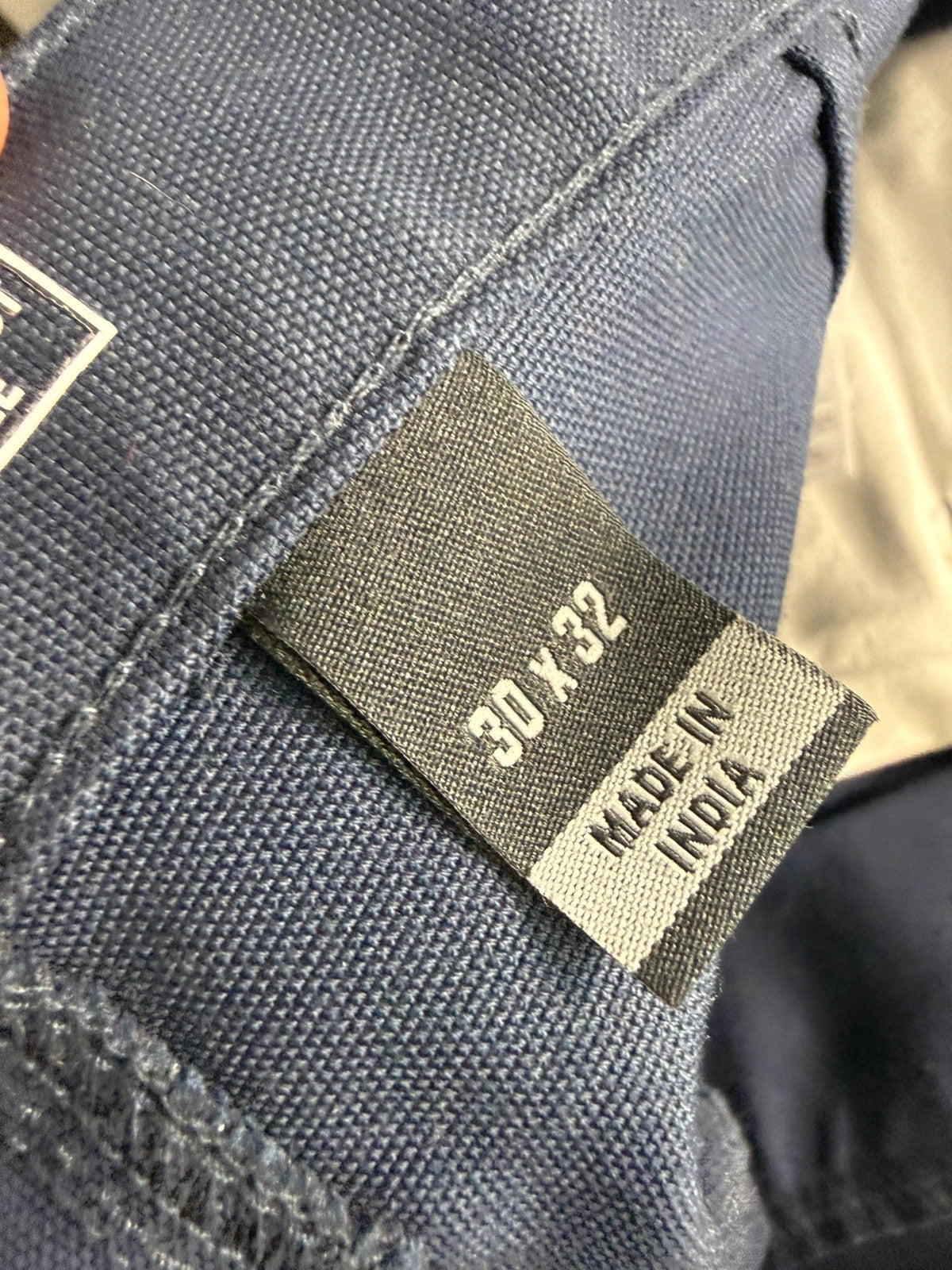 Carhartt navy work trousers with reinforced knees, multiple pockets, and Rugged Flex stretch.