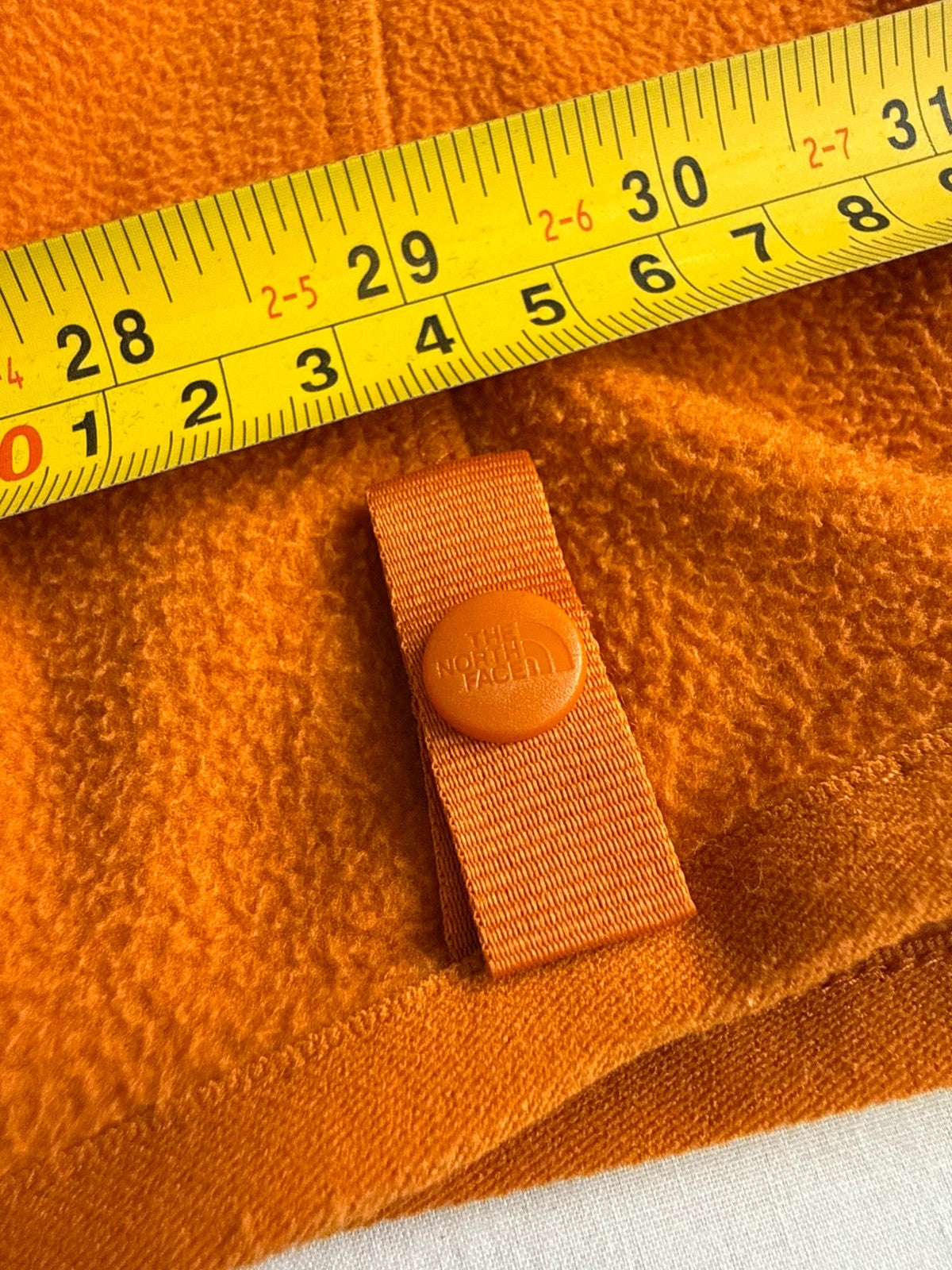 The North Face orange fleece jacket with embroidered logo and high stand collar.